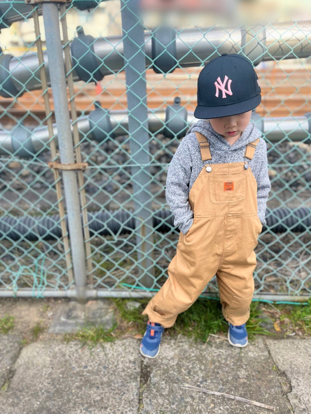 グレー系のパーカー、ブラウン系のオールインワン・サロペット、ブルー系のサロペット/オーバーオールを着用したキッズの春コーディネートの2枚目の写真