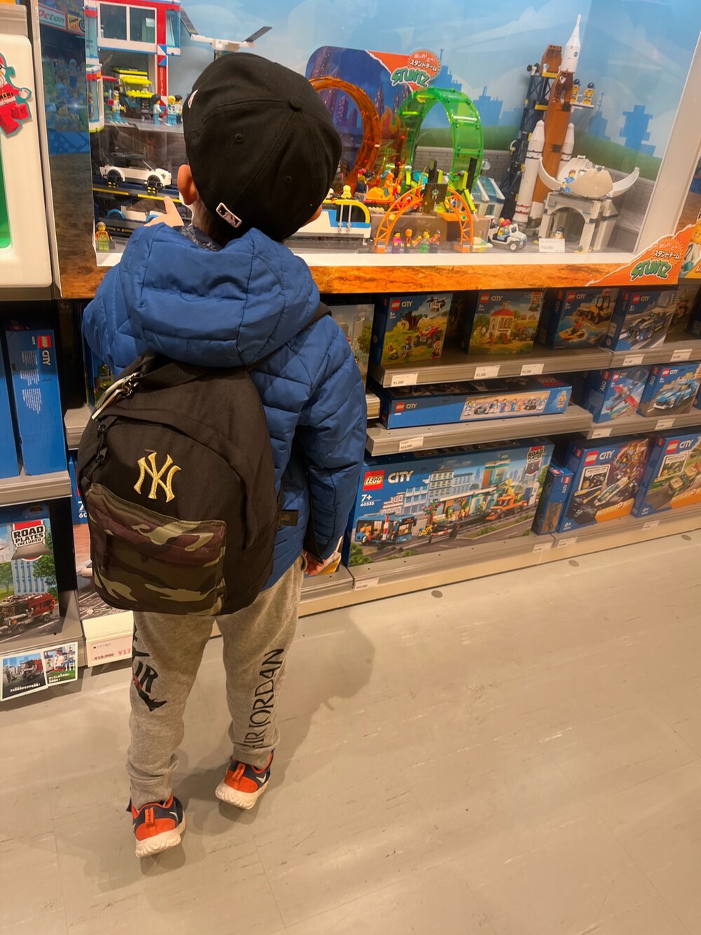 ブルー系のジャケット/アウター、ブルー系のスニーカー、グレー系のスウェットパンツを着用したキッズの冬コーディネートの2枚目の写真