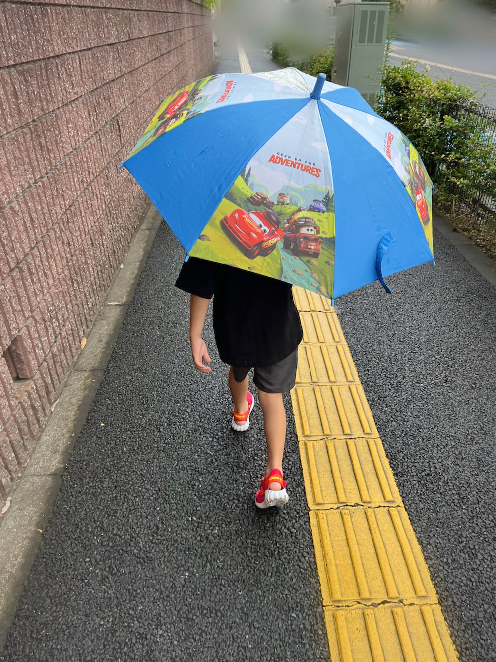ブラック系のTシャツ/カットソー、グレー系のその他パンツ、レッド系のサンダルを着用したキッズの夏コーディネートの2枚目の写真