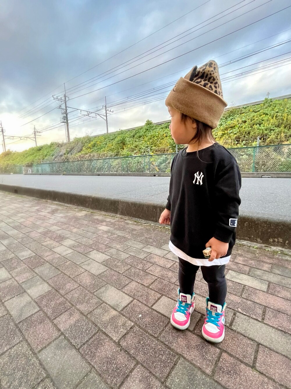 ピンク系のスニーカー、ブラック系のトップス、ブラウン系のニットキャップ/ビーニーを着用したキッズの秋コーディネートの2枚目の写真