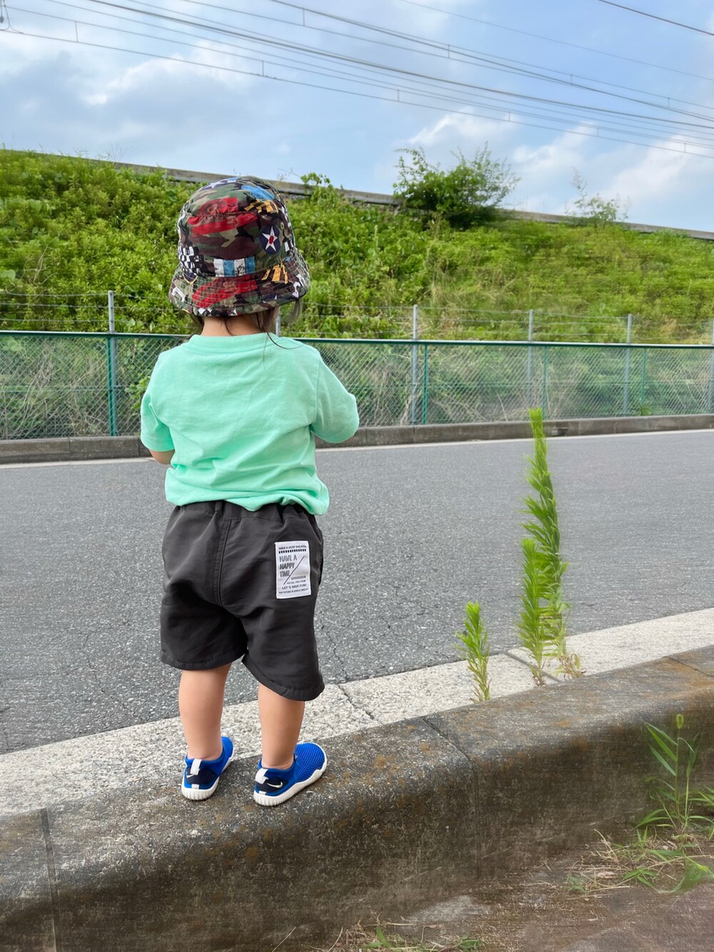 ブルー系のサンダル、グレー系のその他パンツ、グリーン系のTシャツ/カットソーを着用したキッズの夏コーディネートの3枚目の写真