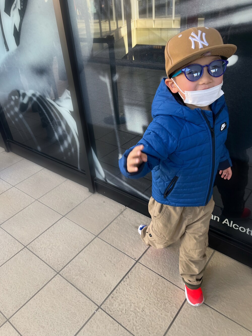 ベージュ系のカーゴパンツ、ブルー系のジャケット/アウター、オレンジ系のスニーカーを着用したキッズの冬コーディネートの2枚目の写真