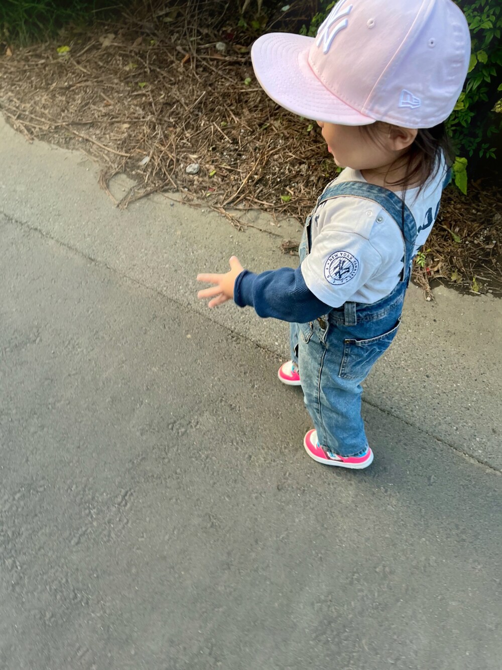 ブルー系のトップス、ピンク系のスニーカー、ピンク系のキャップを着用したキッズの秋コーディネートの2枚目の写真