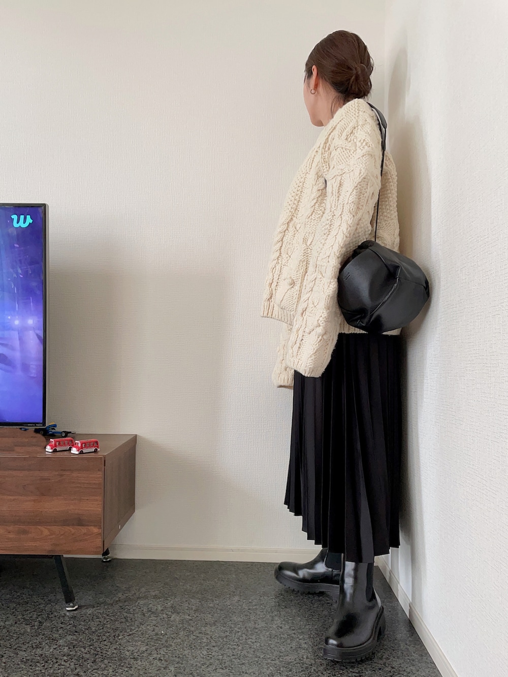 ホワイト系のニット/セーター、ブラック系のスカート、ブラック系のブーツを着用したレディースの秋コーディネートの3枚目の写真