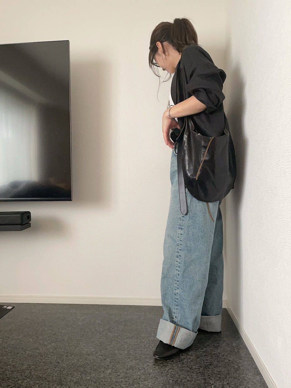 ブラック系のテーラードジャケット、ホワイト系のTシャツ/カットソー、ブラック系のショルダーバッグを着用したレディースの秋コーディネートの2枚目の写真