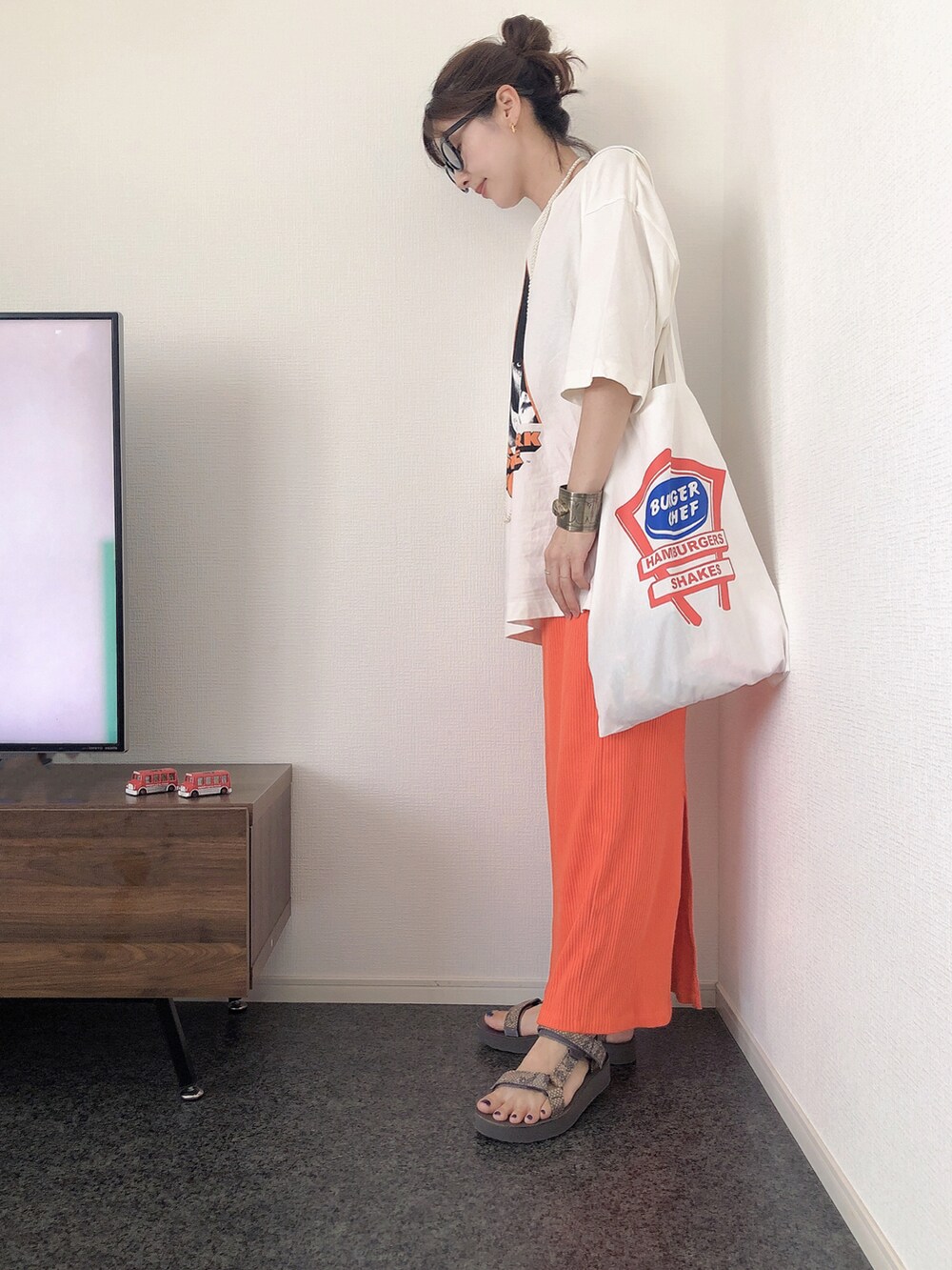 ホワイト系のTシャツ/カットソー、ホワイト系のトートバッグ、オレンジ系のスカートを着用したレディースの夏コーディネートの2枚目の写真