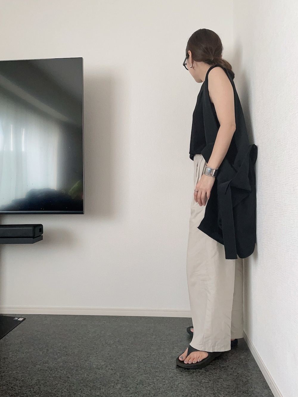 ブラック系のTシャツ/カットソー、ブラック系のトートバッグ、ベージュ系のスラックスを着用したレディースの夏コーディネートの2枚目の写真