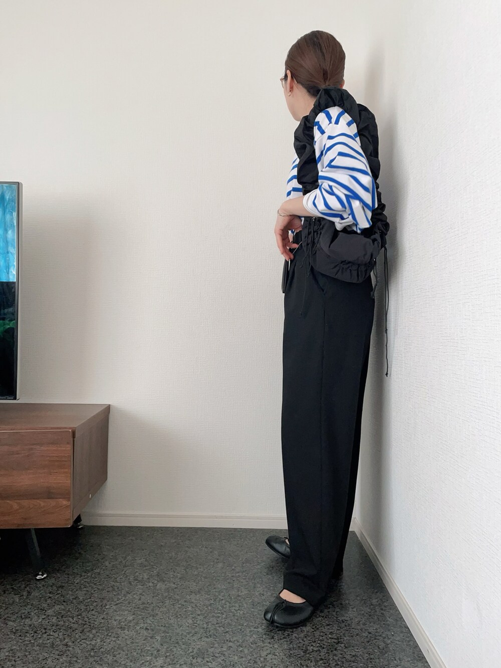 ブルー系のTシャツ/カットソー、ブラック系のハンドバッグ、ブラック系のパンツを着用したレディースの春コーディネートの2枚目の写真