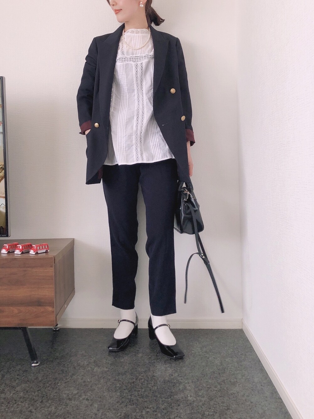 ブルー系のテーラードジャケット、ホワイト系のシャツ/ブラウス、ブラック系のショルダーバッグを着用したレディースの春コーディネートの2枚目の写真