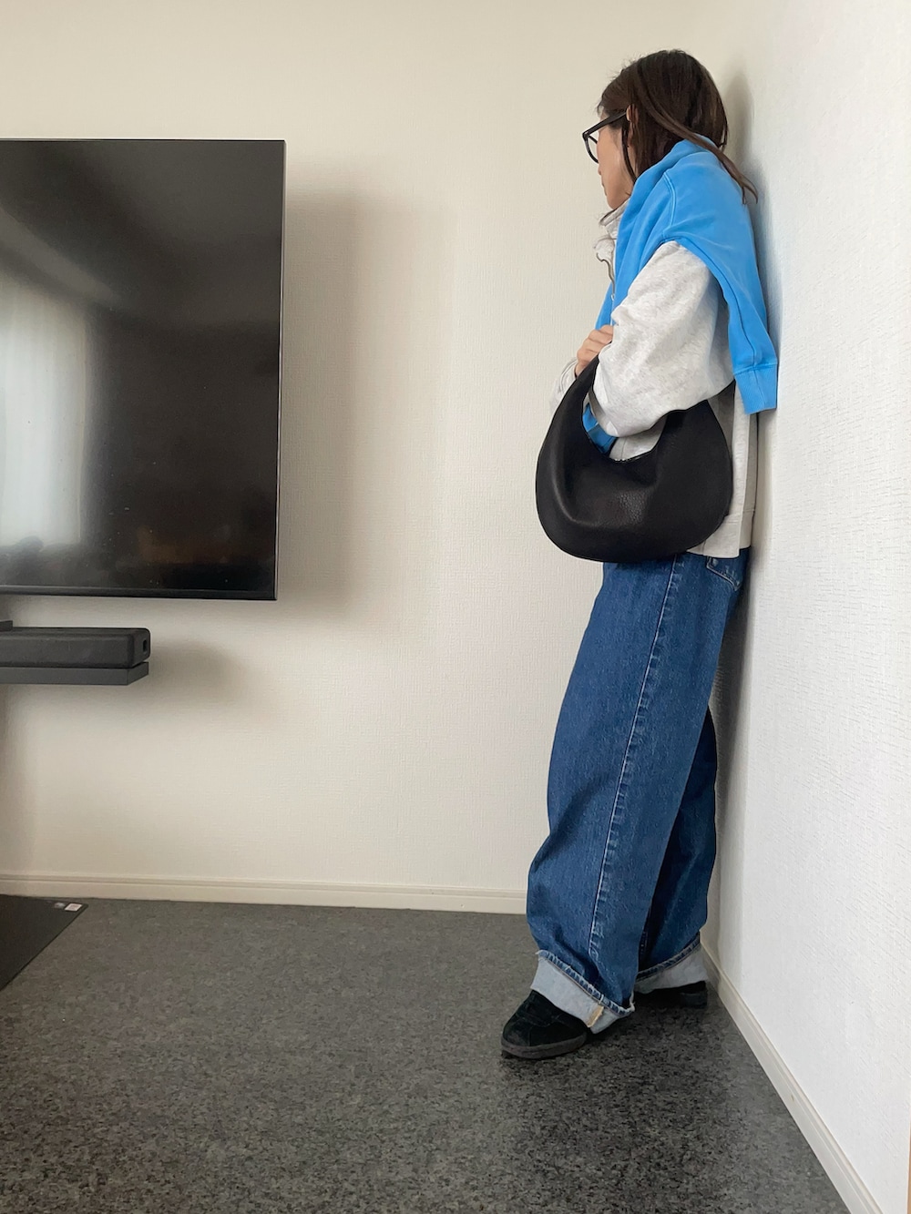 グレー系のスウェット、ブルー系のスウェット、ブラック系のハンドバッグを着用したレディースの冬コーディネートの2枚目の写真
