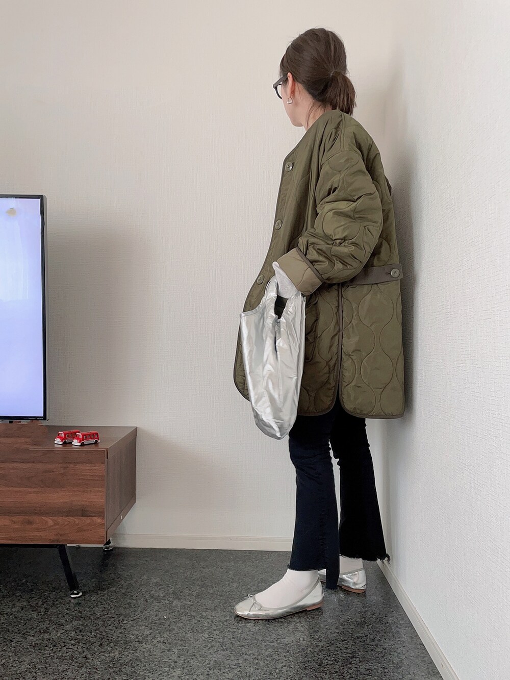 グリーン系のブルゾン、グレー系のスウェット、シルバー系のショルダーバッグを着用したレディースの冬コーディネートの2枚目の写真