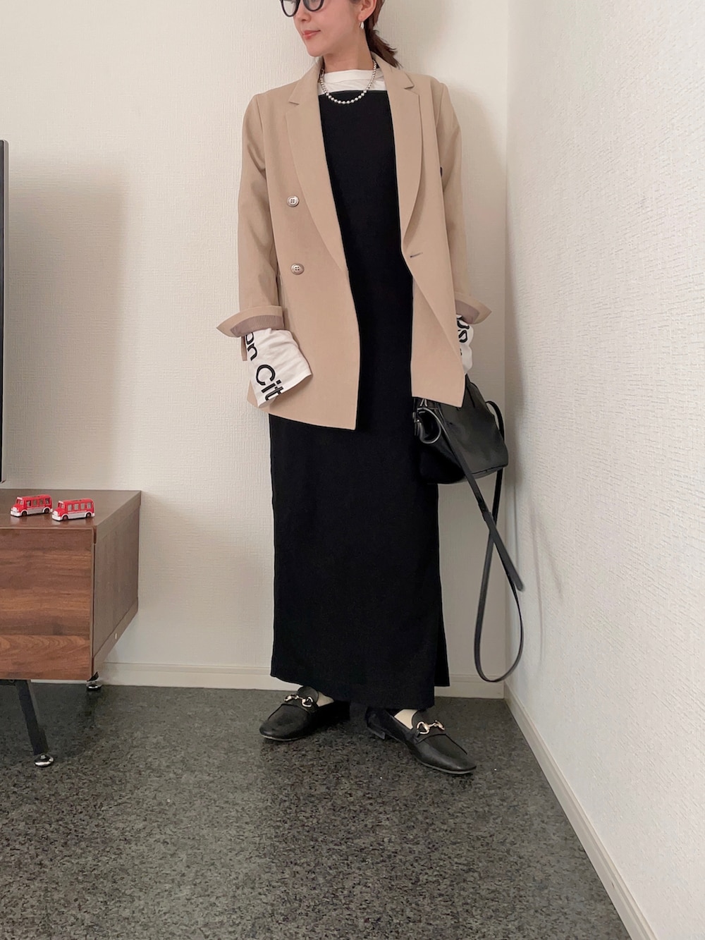 ホワイト系のTシャツ/カットソー、ベージュ系のその他アウター、ブラック系のショルダーバッグを着用したレディースの春コーディネートの2枚目の写真