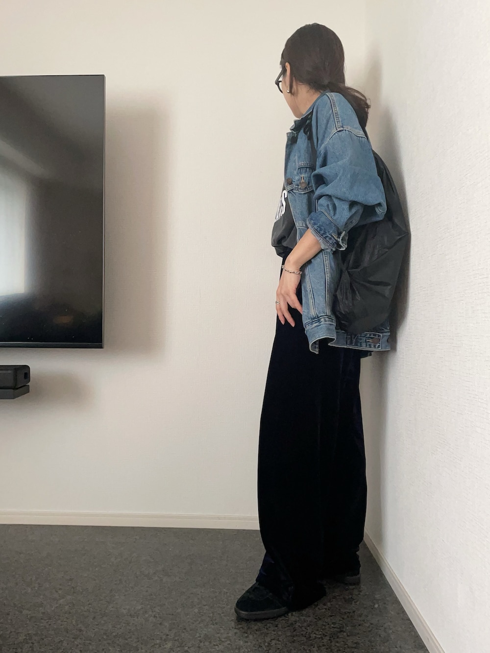 ブラック系のTシャツ/カットソー、ブルー系のデニムジャケット、ブラック系のバッグを着用したレディースの秋コーディネートの2枚目の写真