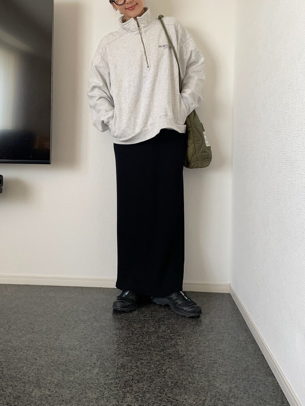 ブラック系のダウンベスト、グレー系のスウェット、グリーン系のショルダーバッグを着用したレディースの冬コーディネートの2枚目の写真