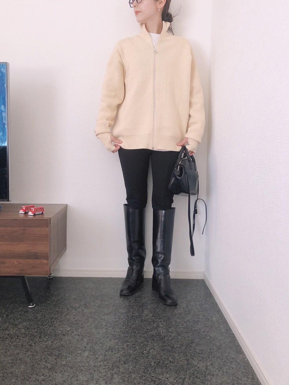 グレー系のその他アウター、ホワイト系のニット/セーター、ブラック系のその他パンツを着用したレディースの冬コーディネートの2枚目の写真