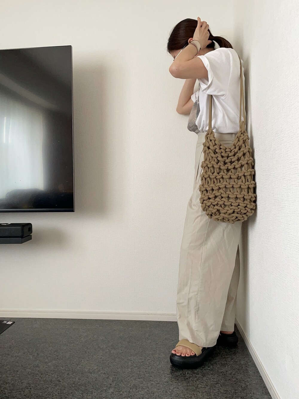 ホワイト系のTシャツ/カットソー、ベージュ系のスラックス、ブラウン系のショルダーバッグを着用したレディースの夏コーディネートの2枚目の写真