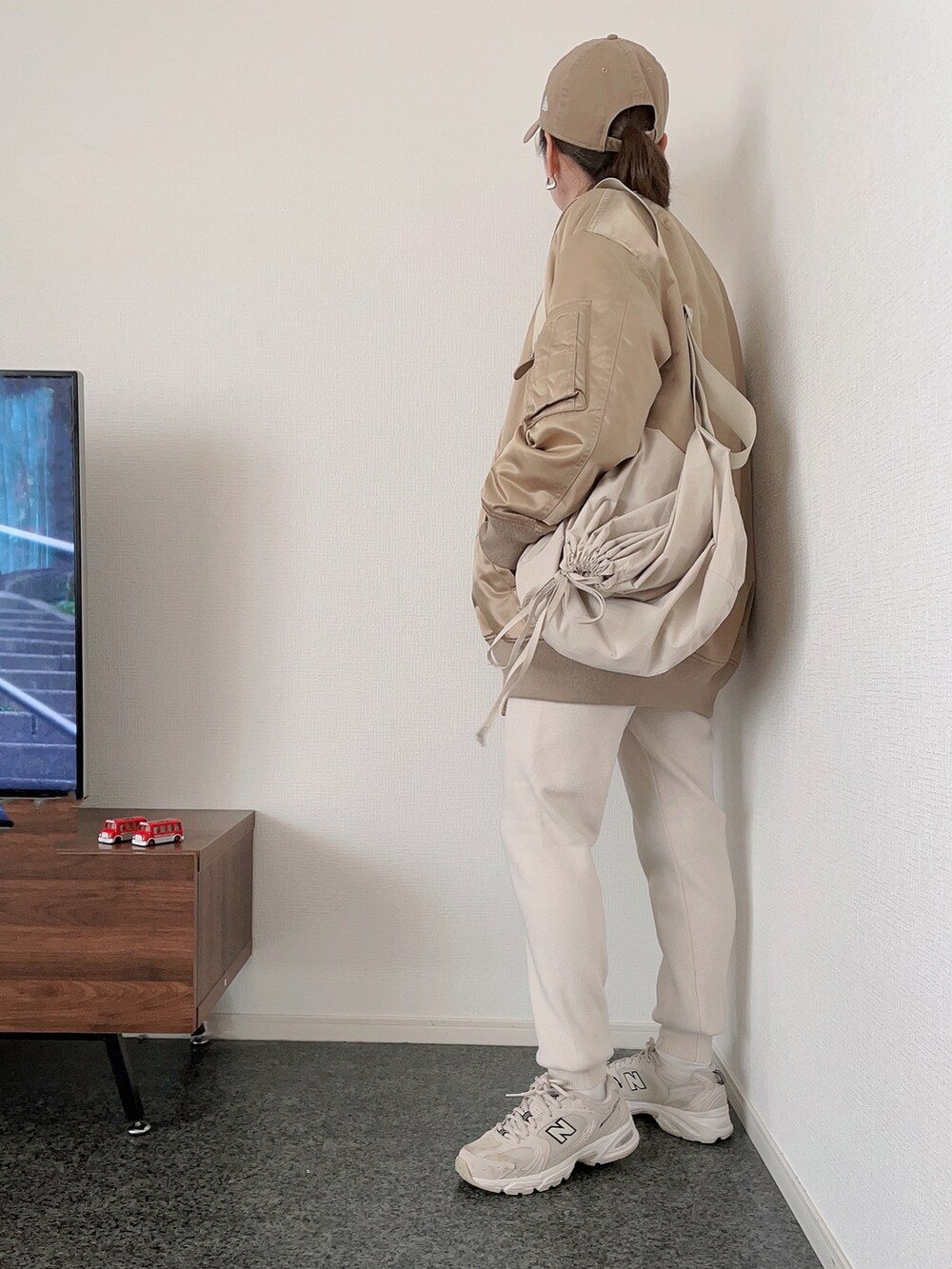 ベージュ系のダウンジャケット/コート、グレー系のスウェット、ホワイト系のショルダーバッグを着用したレディースの冬コーディネートの2枚目の写真