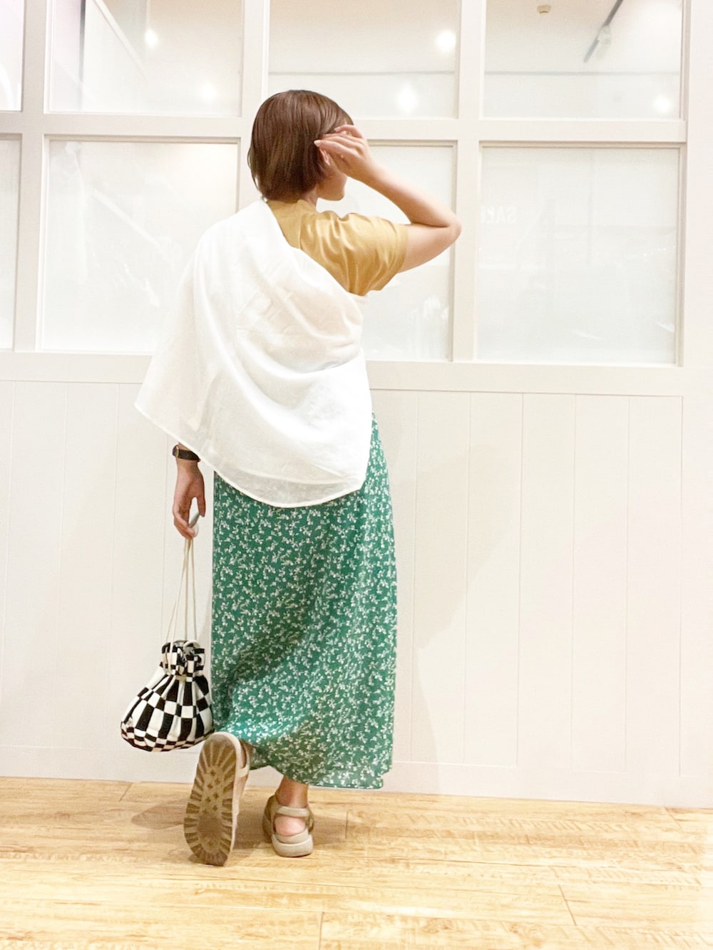 グリーン系のスカート、ブラック系のバッグ、その他のトップスを着用したレディースの夏コーディネートの2枚目の写真