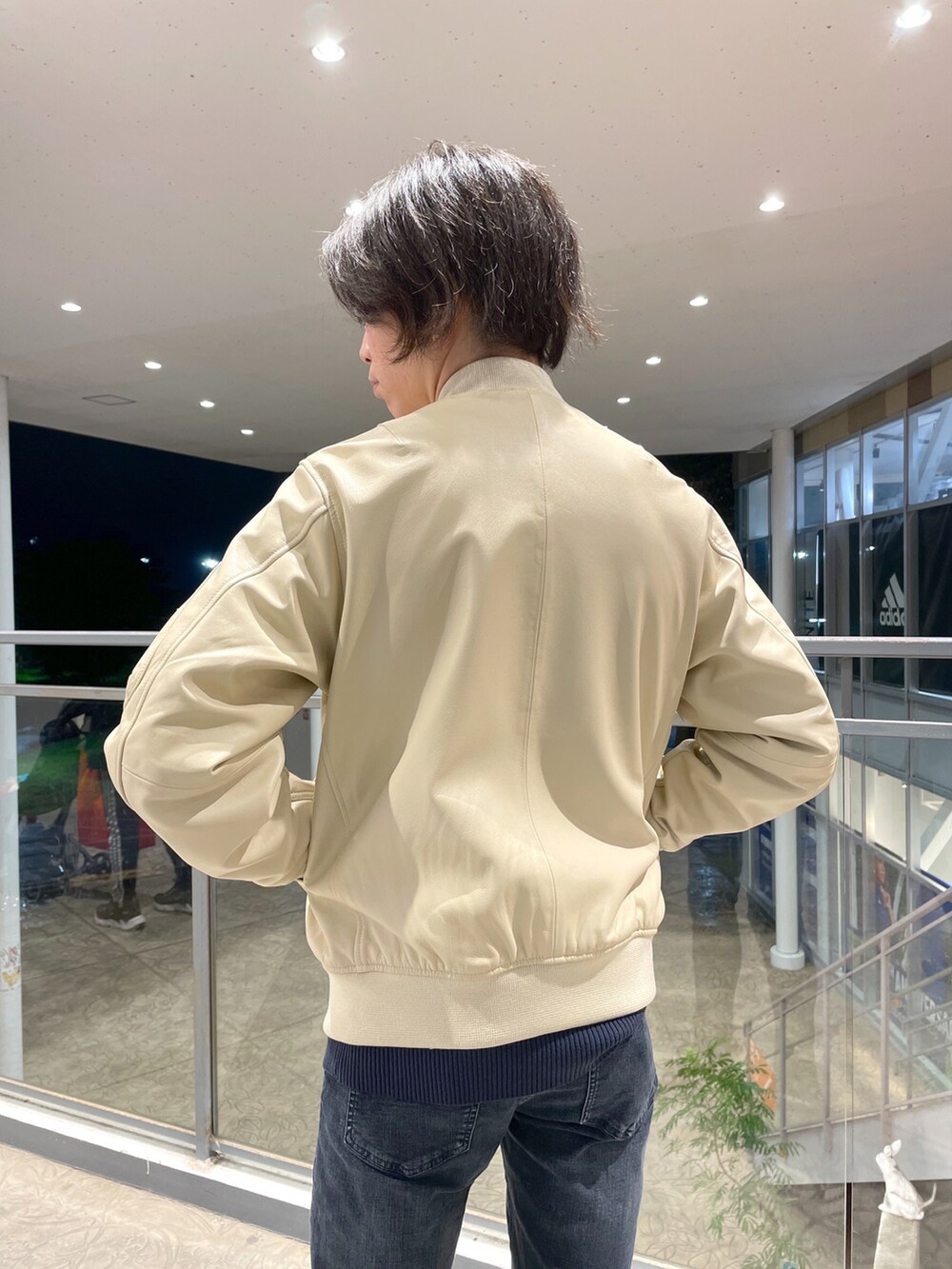 ブルー系のニット/セーター、ホワイト系のMA-1、ブルー系のデニムパンツを着用したメンズの秋コーディネートの3枚目の写真