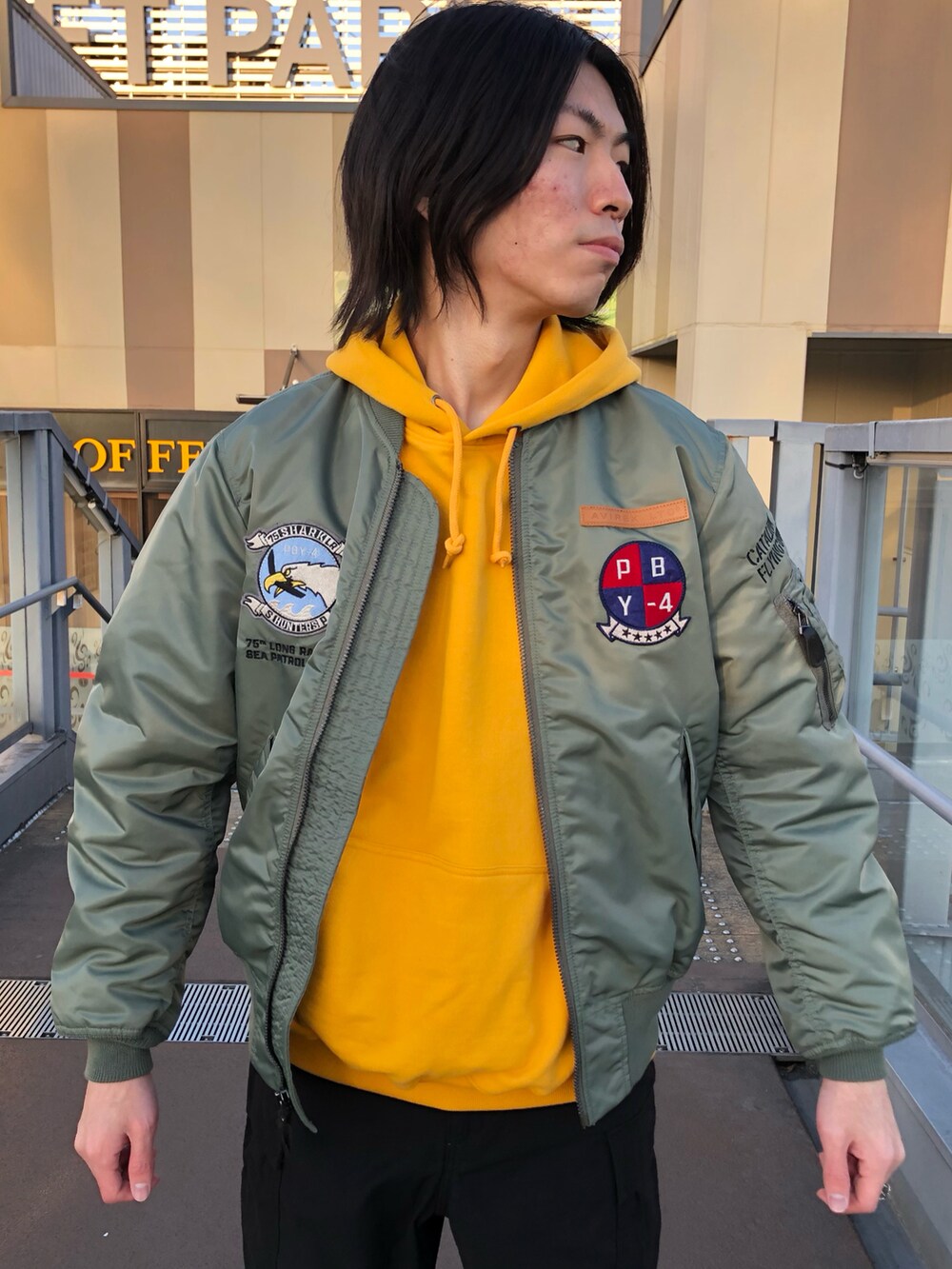 イエロー系のパーカー、その他のMA-1、ブラック系のスリッポンを着用したメンズの冬コーディネートの3枚目の写真