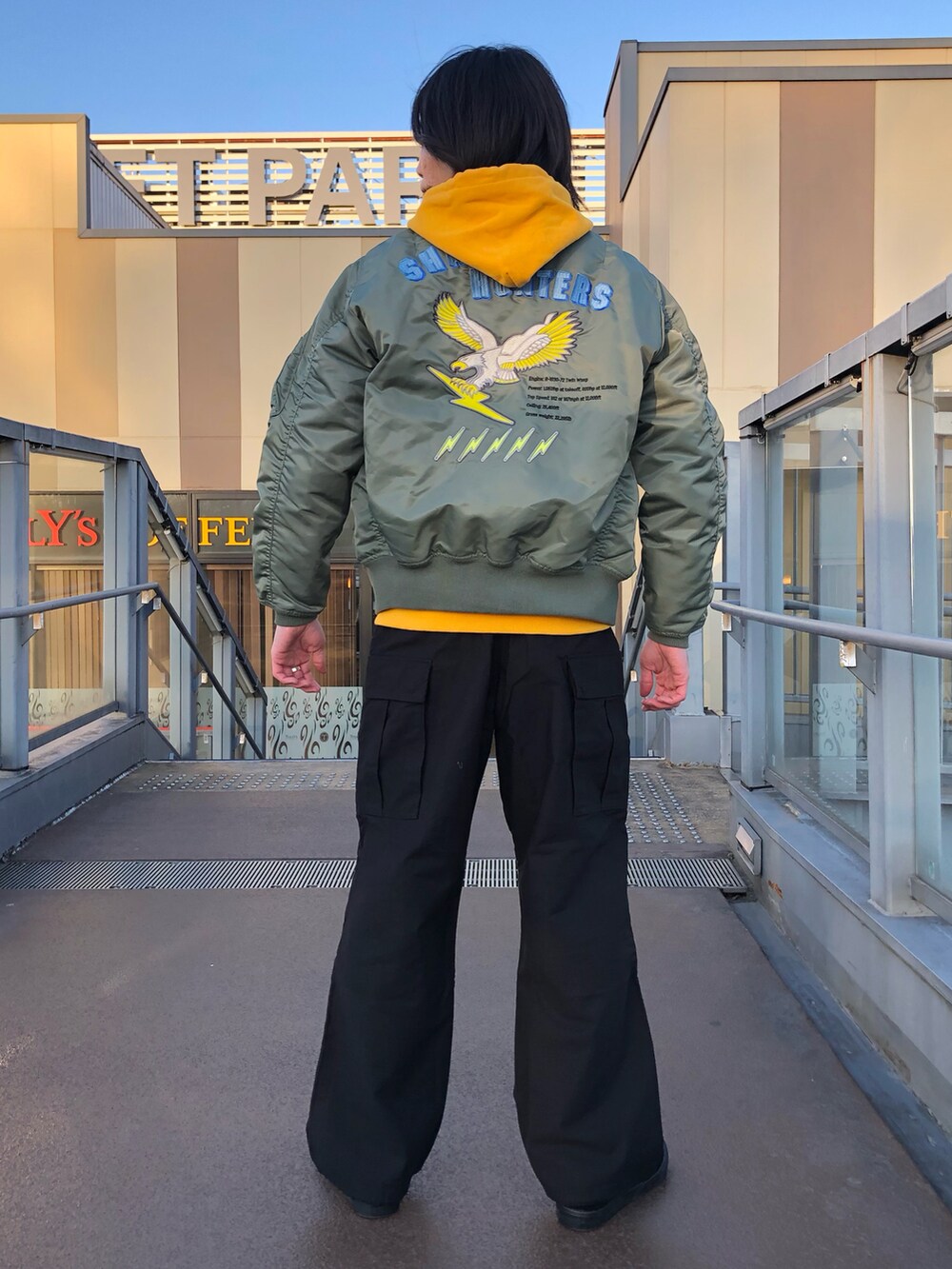 イエロー系のパーカー、その他のMA-1、ブラック系のスリッポンを着用したメンズの冬コーディネートの2枚目の写真