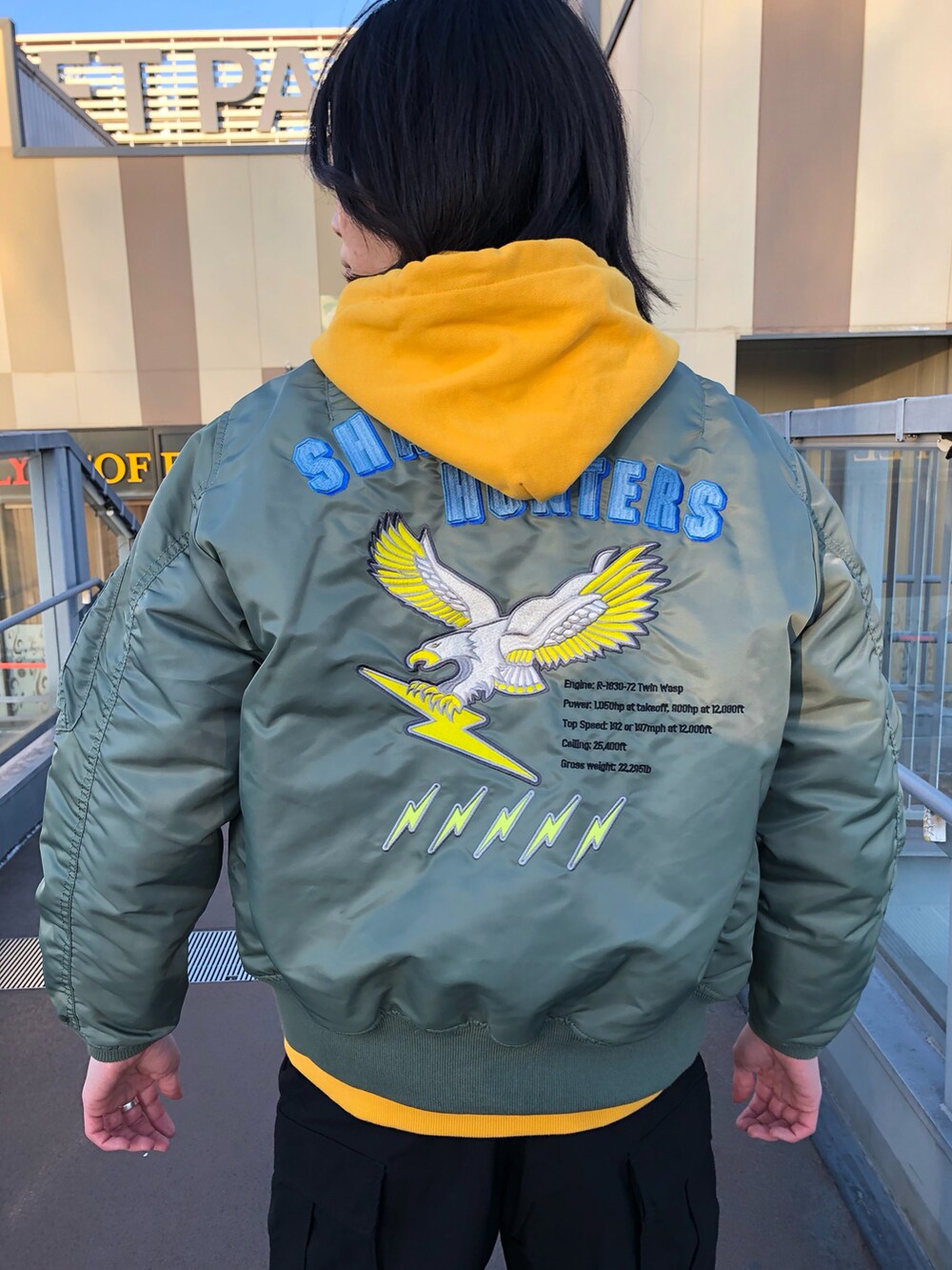 イエロー系のパーカー、その他のMA-1、ブラック系のスリッポンを着用したメンズの冬コーディネートの4枚目の写真