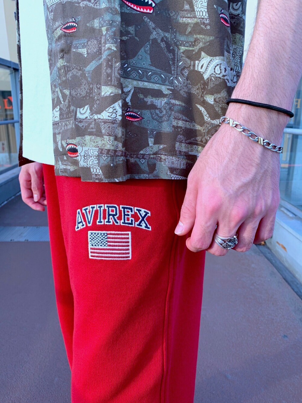 グリーン系のシャツ/ブラウス、ホワイト系のTシャツ/カットソー、レッド系のスウェットパンツを着用したメンズの夏コーディネートの3枚目の写真