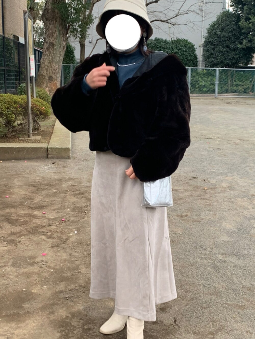 ブルー系のニット/セーター、シルバー系のトートバッグ、グレー系のスカートを着用したレディースの冬コーディネートの2枚目の写真