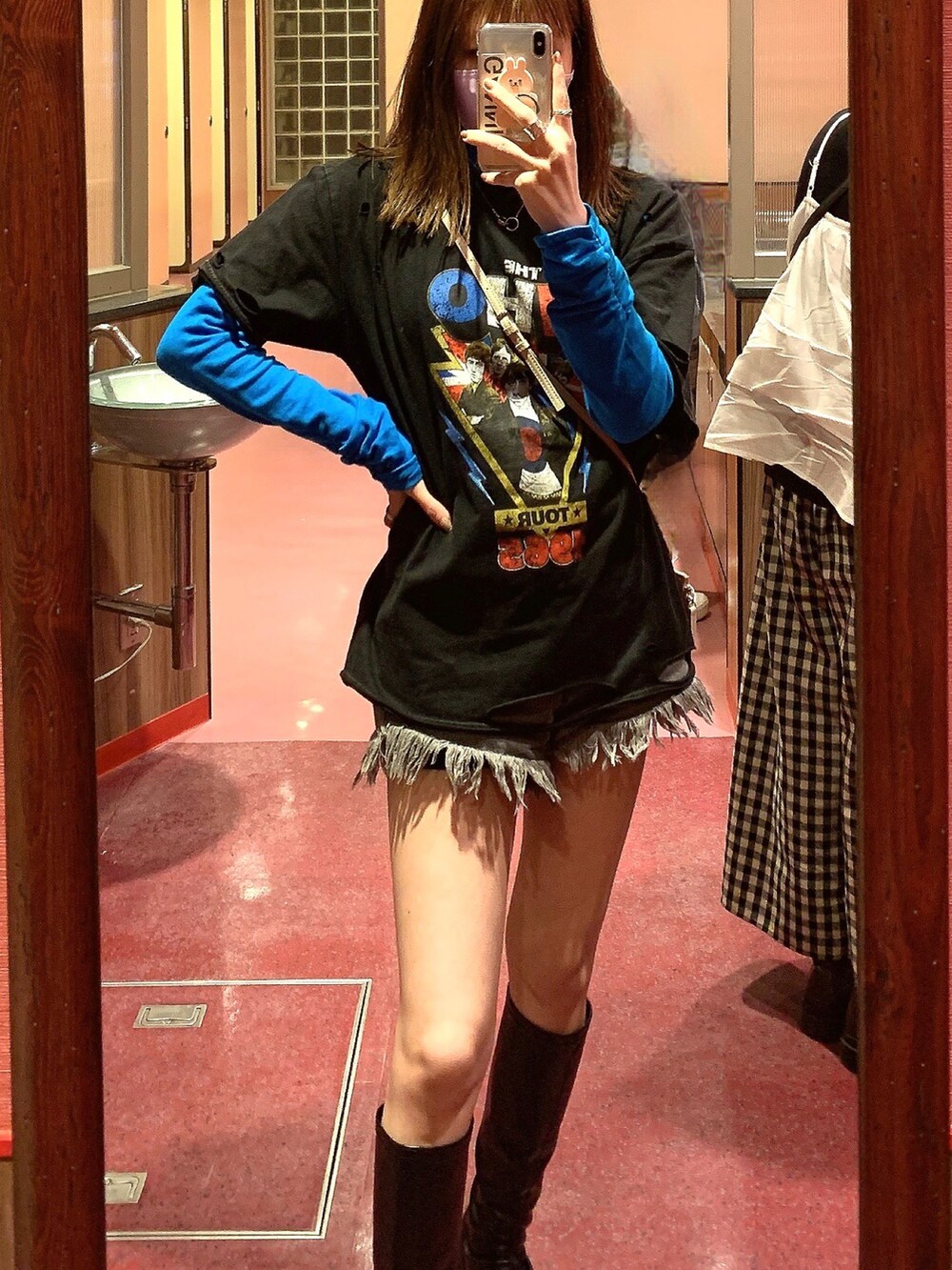 ブラック系のブーツ、ブラック系のデニムパンツ、ブラック系のデニムパンツを着用したレディースの春コーディネートの2枚目の写真