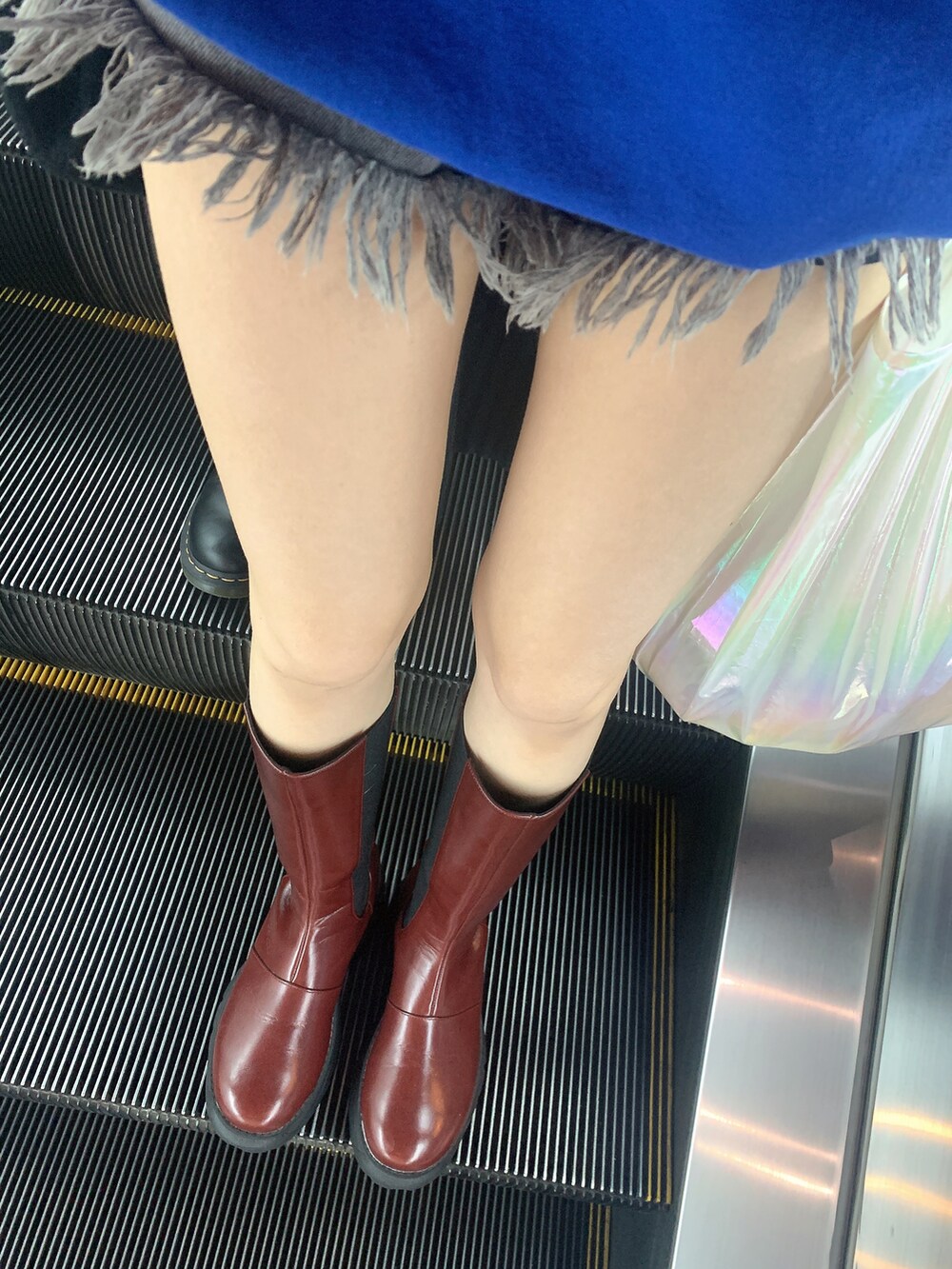 レッド系のブーツ、ブラック系のデニムパンツ、ブルー系のスウェットを着用したレディースの冬コーディネートの2枚目の写真