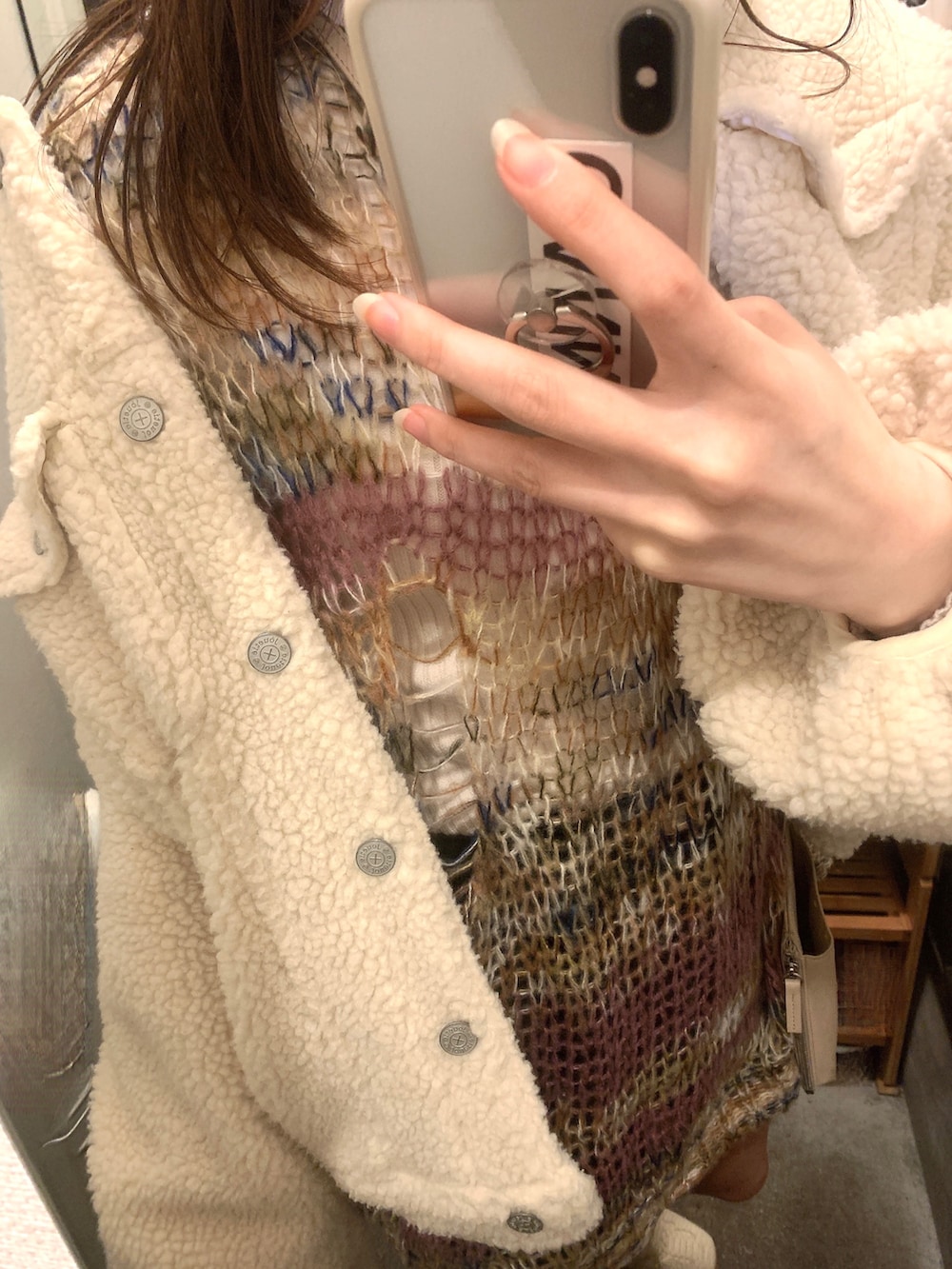 ホワイト系のブーツ、ホワイト系のショルダーバッグ、ホワイト系のブルゾンを着用したレディースの冬コーディネートの2枚目の写真