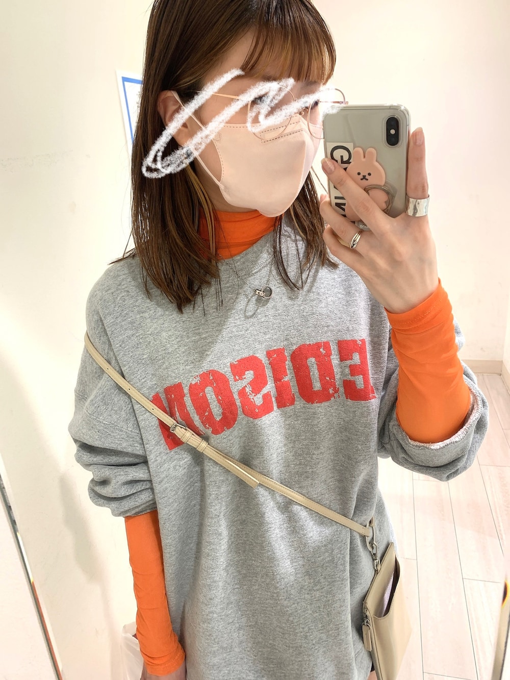 シルバー系のトートバッグ、ブラック系のブーツ、ホワイト系のショルダーバッグを着用したレディースの春コーディネートの2枚目の写真