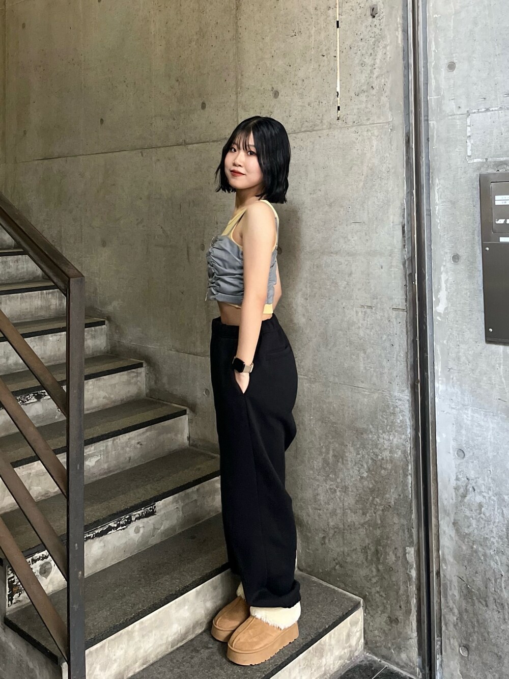 ベージュ系のブーツ、ブラック系のスウェットパンツ、ブラック系のパーカーを着用したレディースの秋コーディネートの2枚目の写真