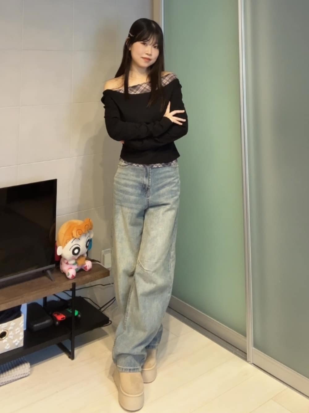 ブラック系のトップス、ブルー系のデニムパンツ、ベージュ系のブーツを着用したレディースの冬コーディネートの3枚目の写真