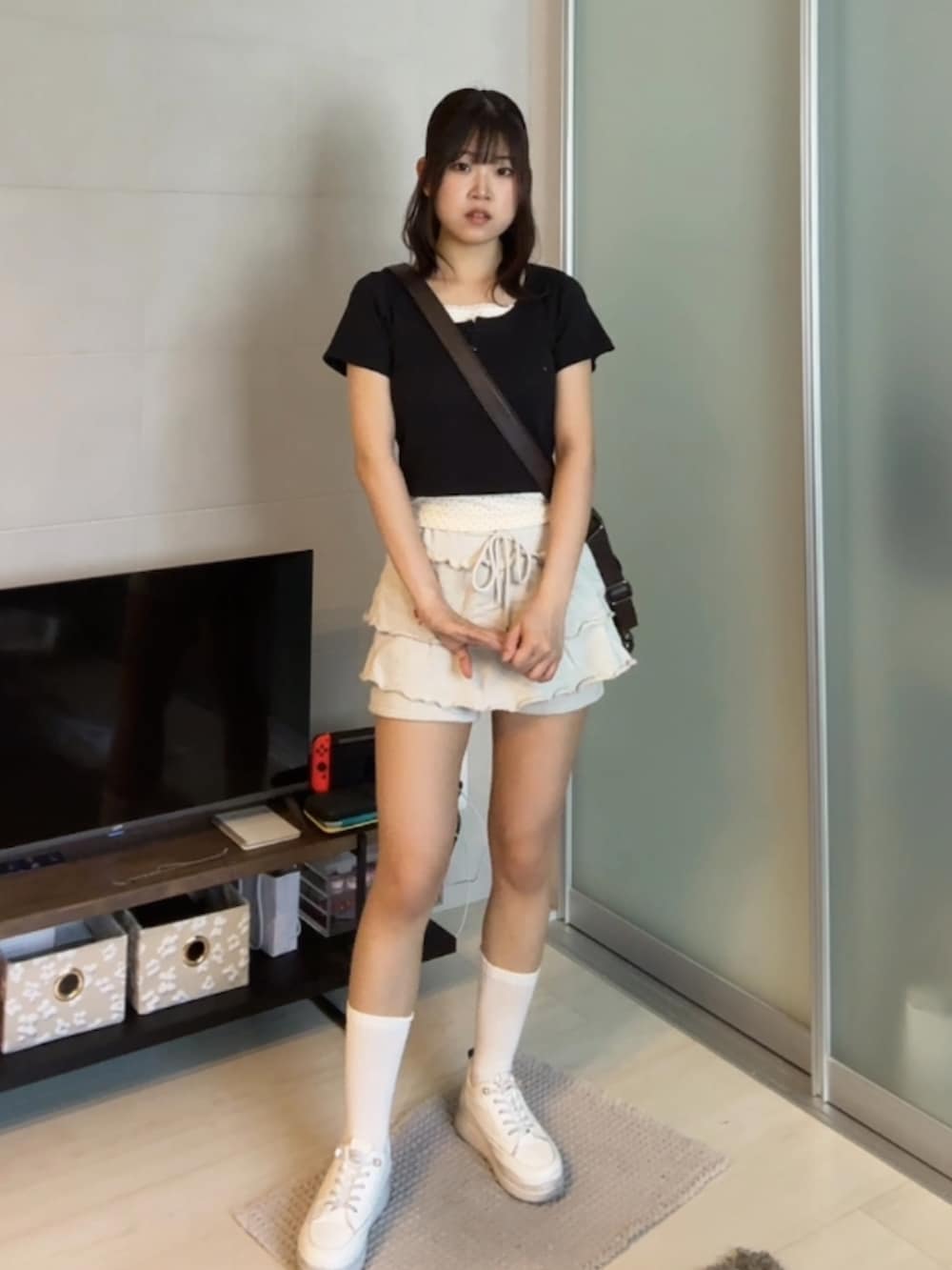 ホワイト系のスニーカー、ホワイト系のスウェットパンツ、ブラック系のTシャツ/カットソーを着用したレディースの夏コーディネートの2枚目の写真