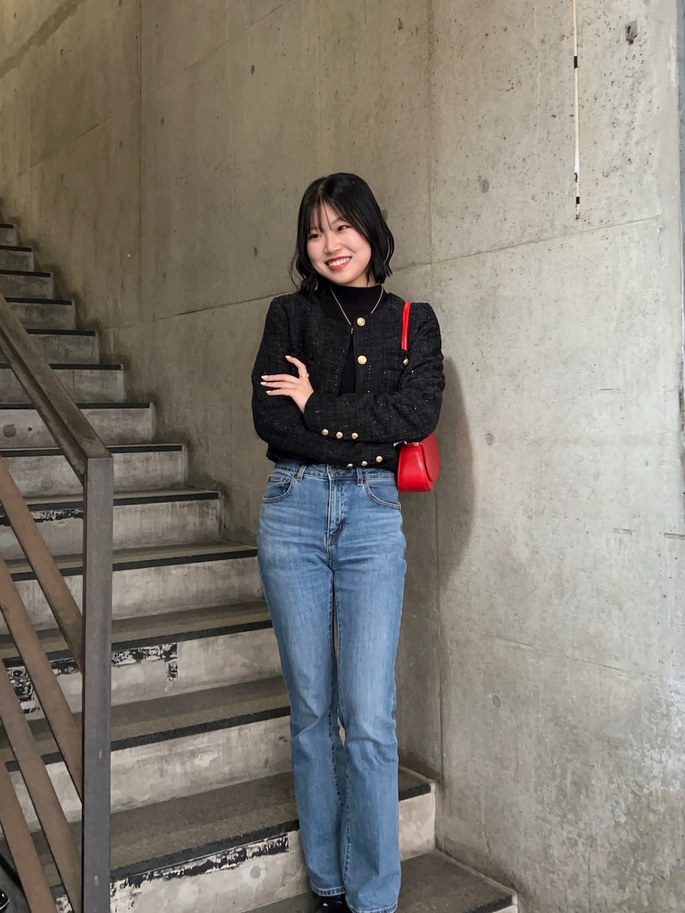 ブルー系のデニムパンツ、ブラック系のニット/セーター、ブラック系のノーカラージャケットを着用したレディースの秋コーディネートの3枚目の写真