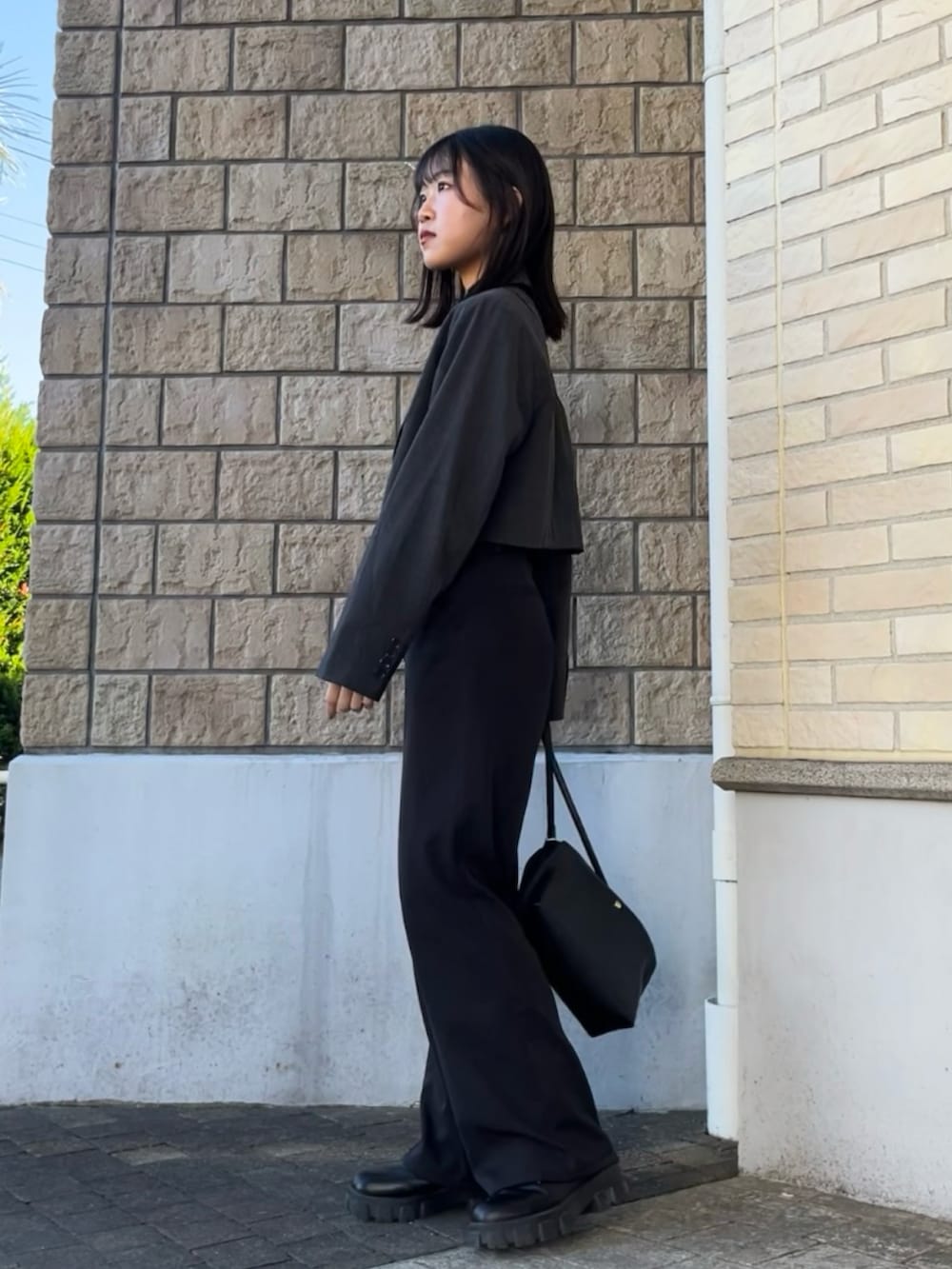 ブラック系のショルダーバッグ、ブラック系のブーツ、ブラック系のTシャツ/カットソーを着用したレディースの秋コーディネートの4枚目の写真