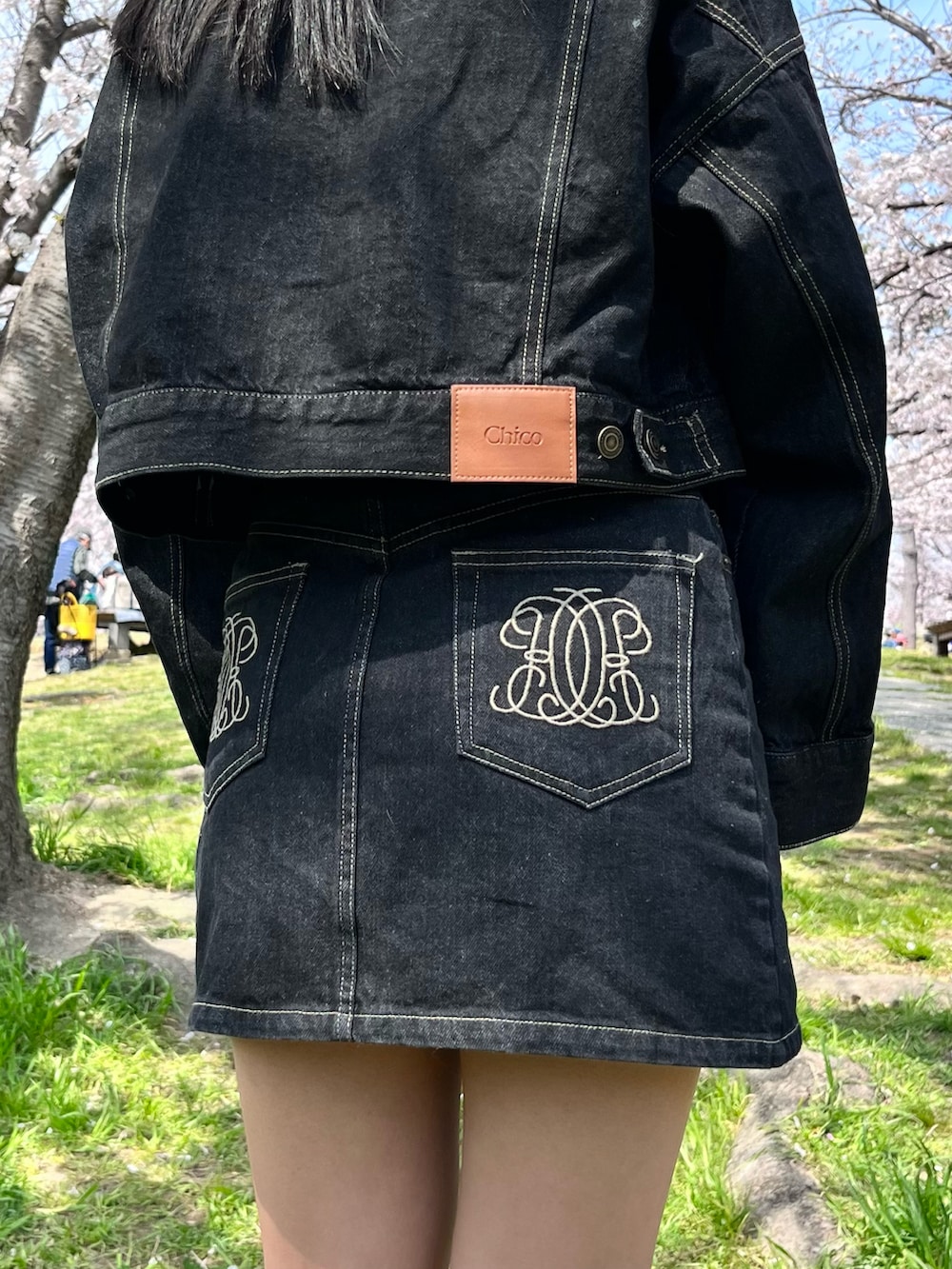 ベージュ系のショルダーバッグ、ブラック系のデニムジャケット、ブラック系のデニムスカートを着用したレディースの春コーディネートの3枚目の写真