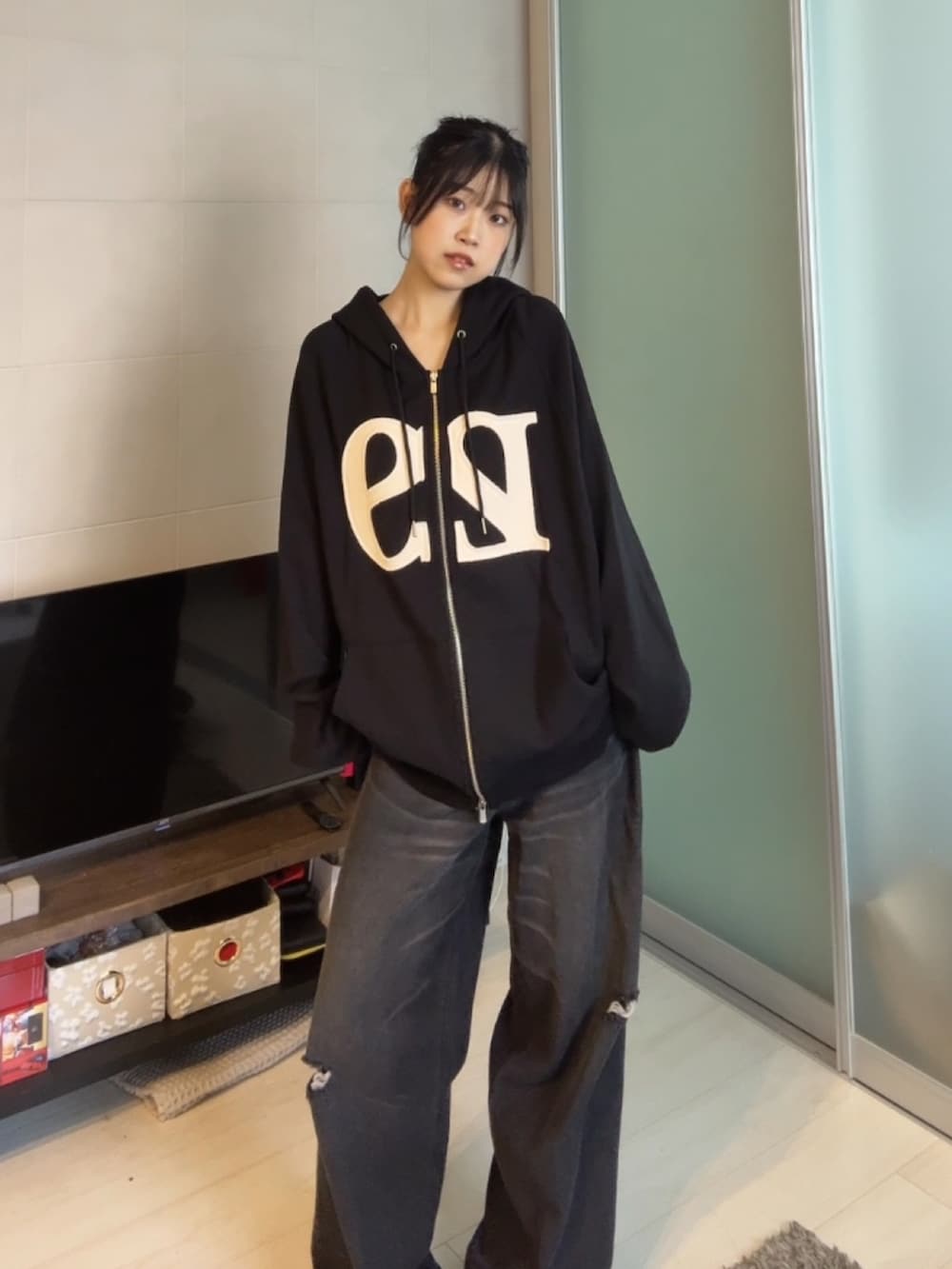 ブラック系のデニムパンツ、ブラック系のパーカーを着用したレディースの秋コーディネートの2枚目の写真