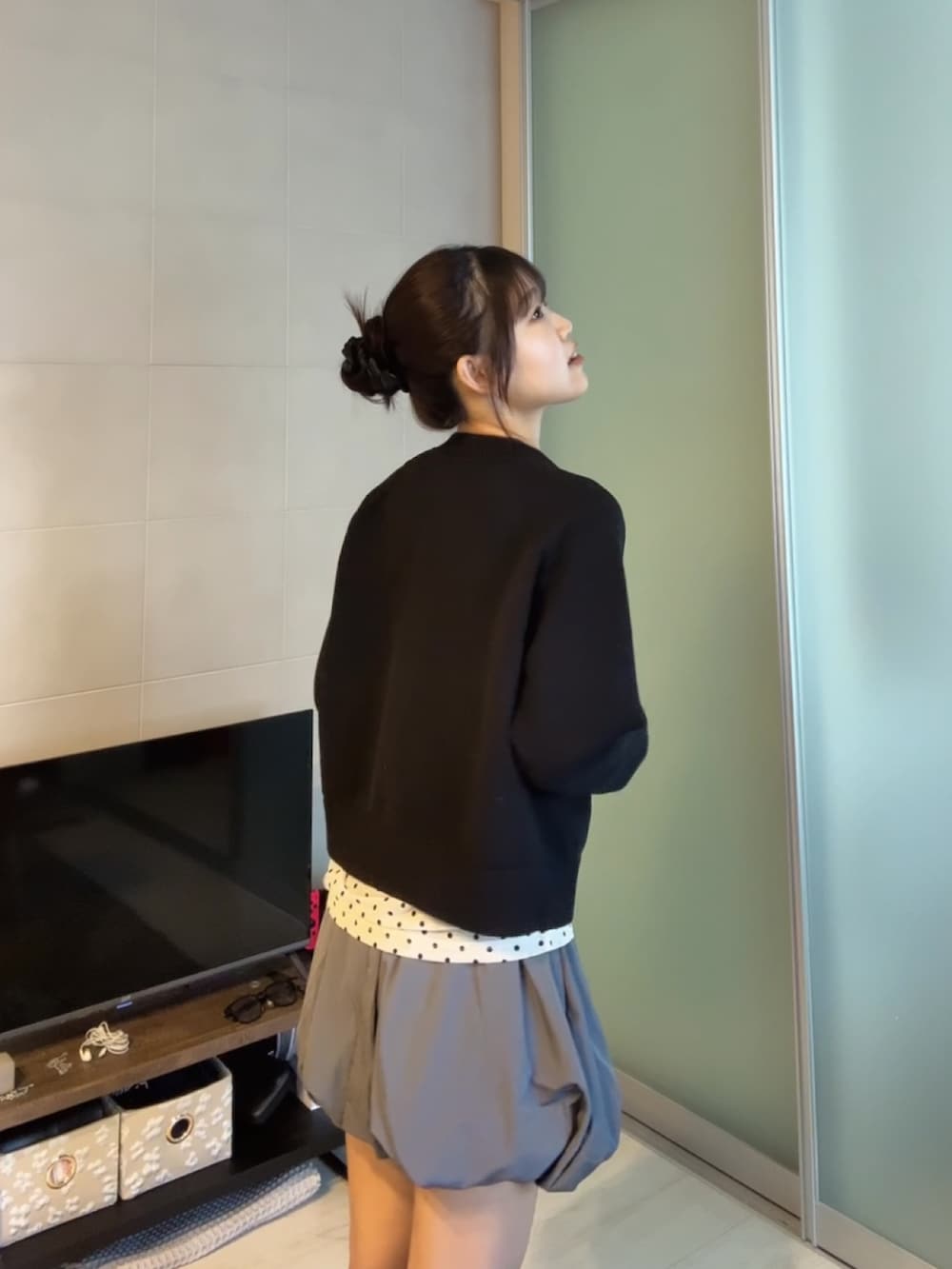 ブラック系のカーディガン/ボレロ、グレー系のスカート、ベージュ系のTシャツ/カットソーを着用したレディースの秋コーディネートの3枚目の写真