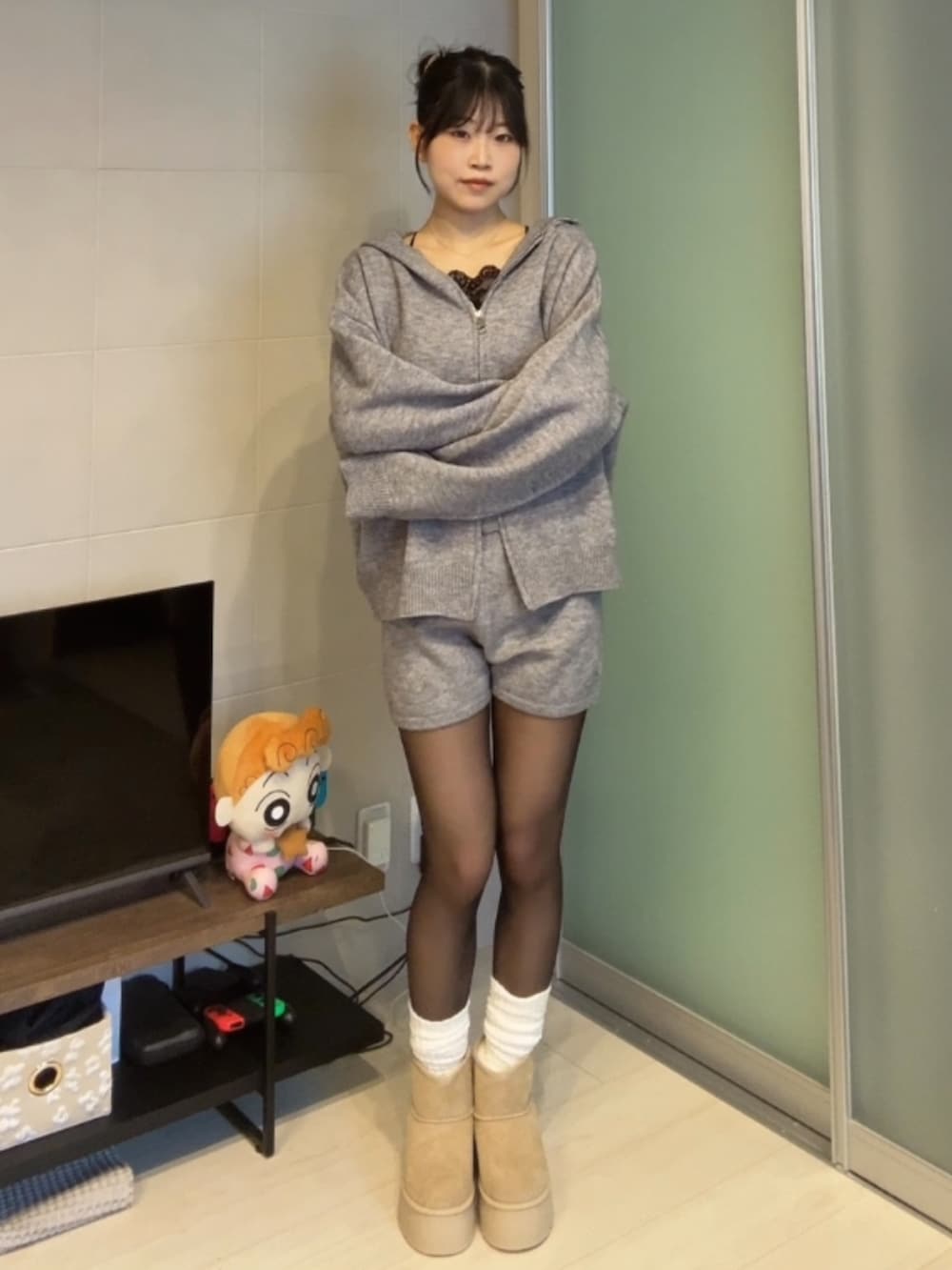 グレー系のニット/セーター、ベージュ系のブーツ、ホワイト系のソックス/靴下を着用したレディースの冬コーディネートの2枚目の写真