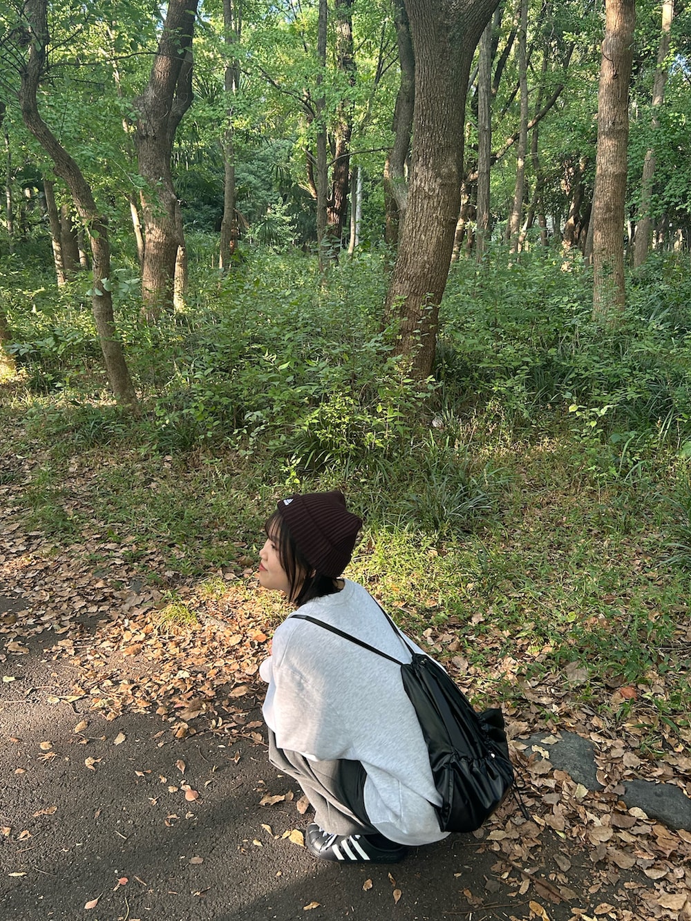 グレー系のスラックス、ブラック系のバックパック/リュック、ブラック系のスウェットを着用したレディースの秋コーディネートの4枚目の写真