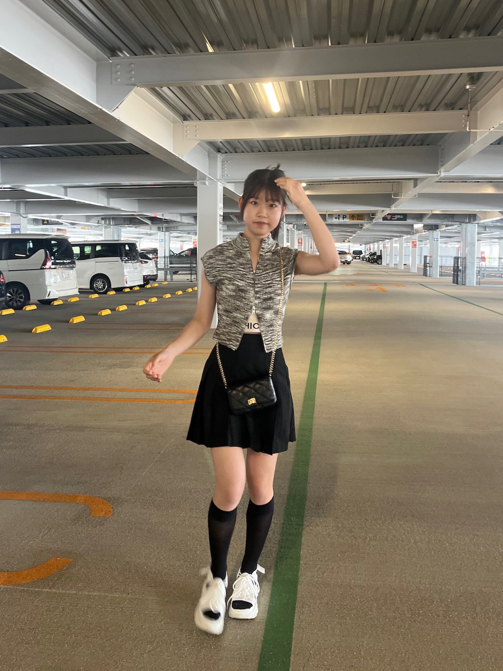 ホワイト系のサンダル、ブラック系のショルダーバッグ、ブラック系のスカートを着用したレディースの夏コーディネートの3枚目の写真