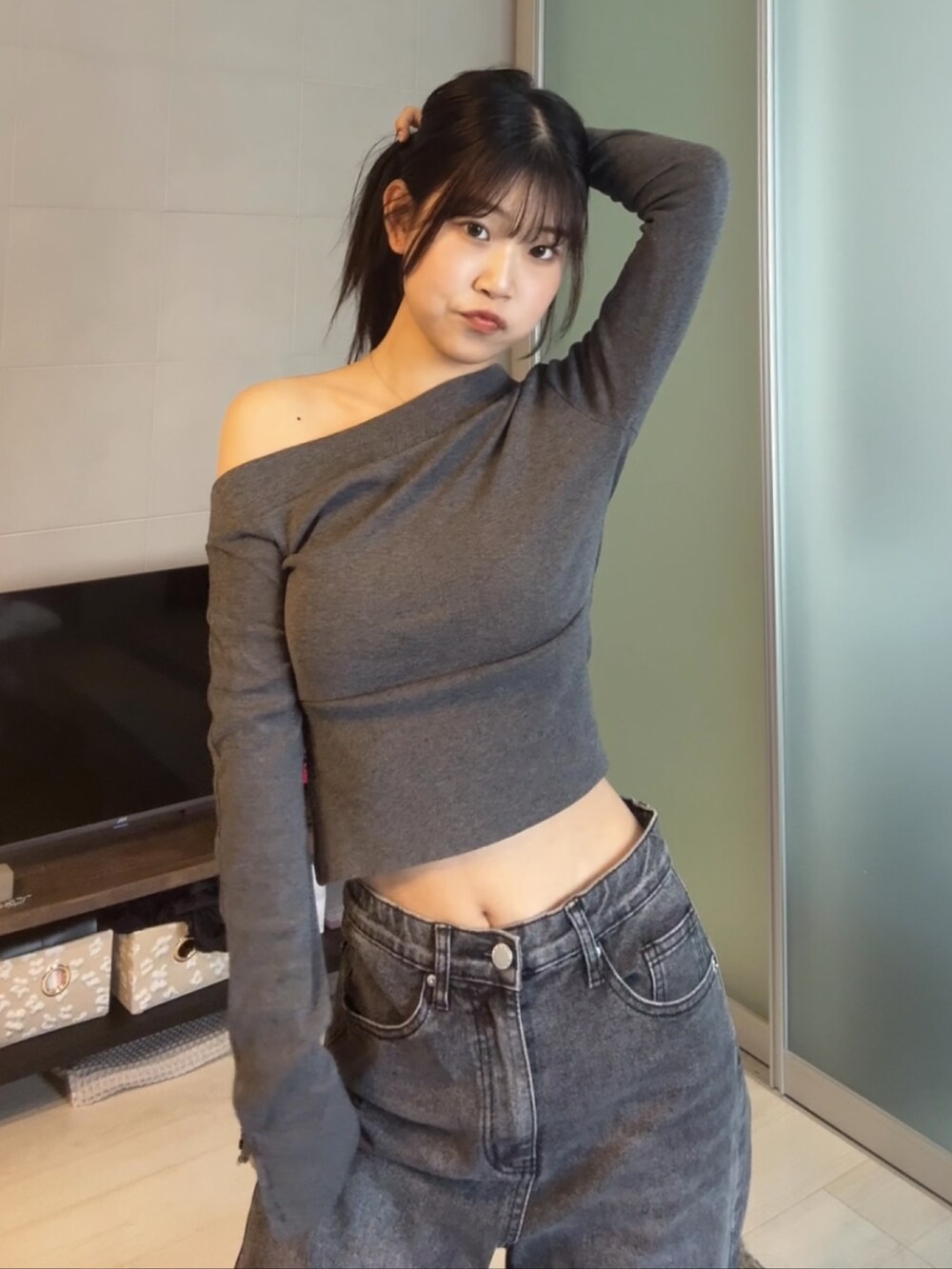 ブラック系のデニムパンツ、グレー系のTシャツ/カットソー、ブラック系のショルダーバッグを着用したレディースの秋コーディネートの3枚目の写真