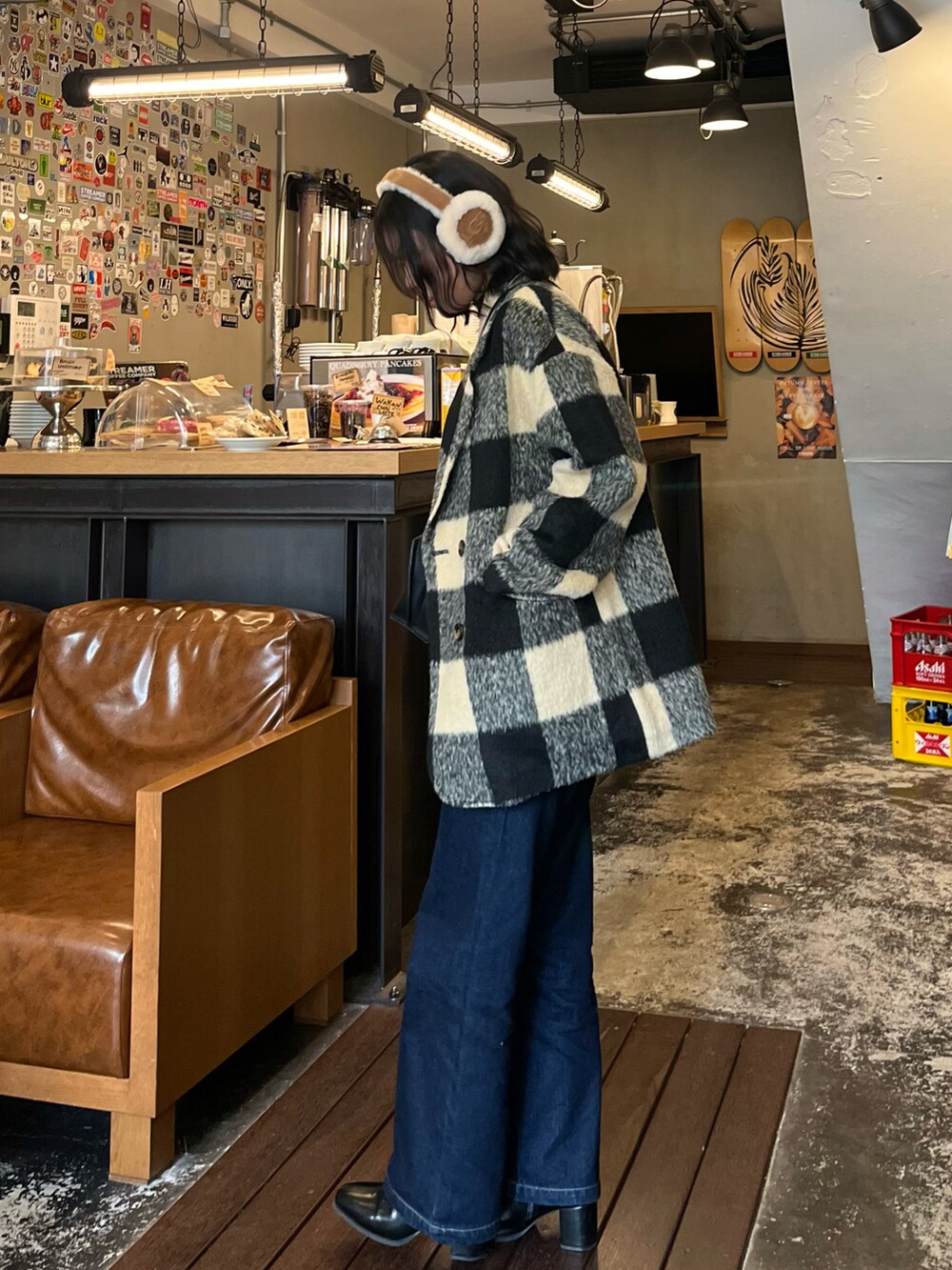 ホワイト系のテーラードジャケット、ブルー系のデニムパンツ、ブラック系のブーツを着用したレディースの冬コーディネートの2枚目の写真