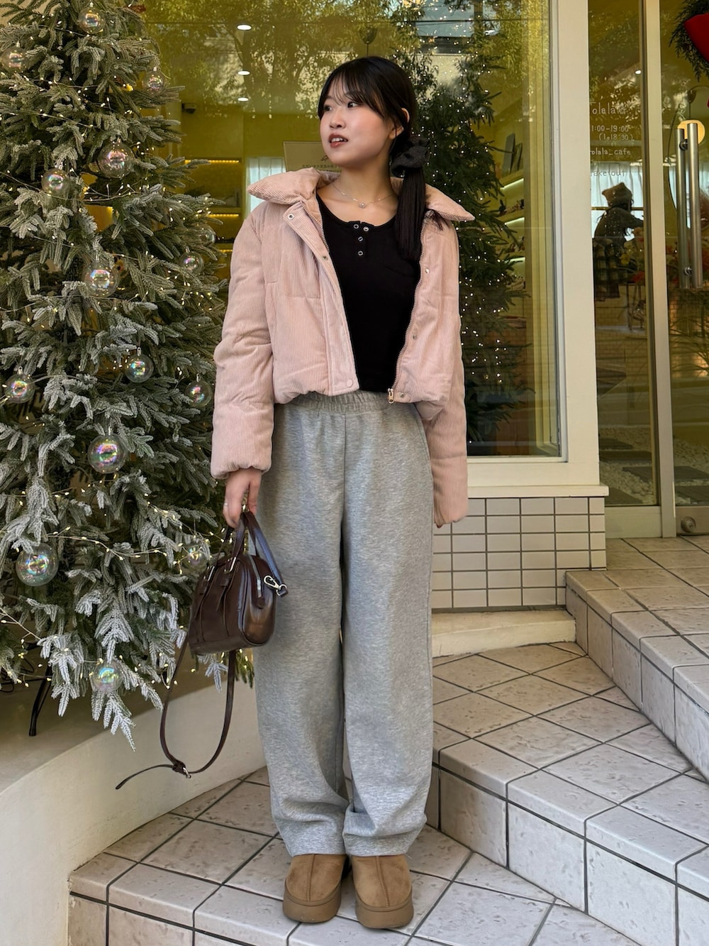 ブラウン系のショルダーバッグ、グレー系のスウェットパンツ、ベージュ系のブーツを着用したレディースの冬コーディネートの2枚目の写真