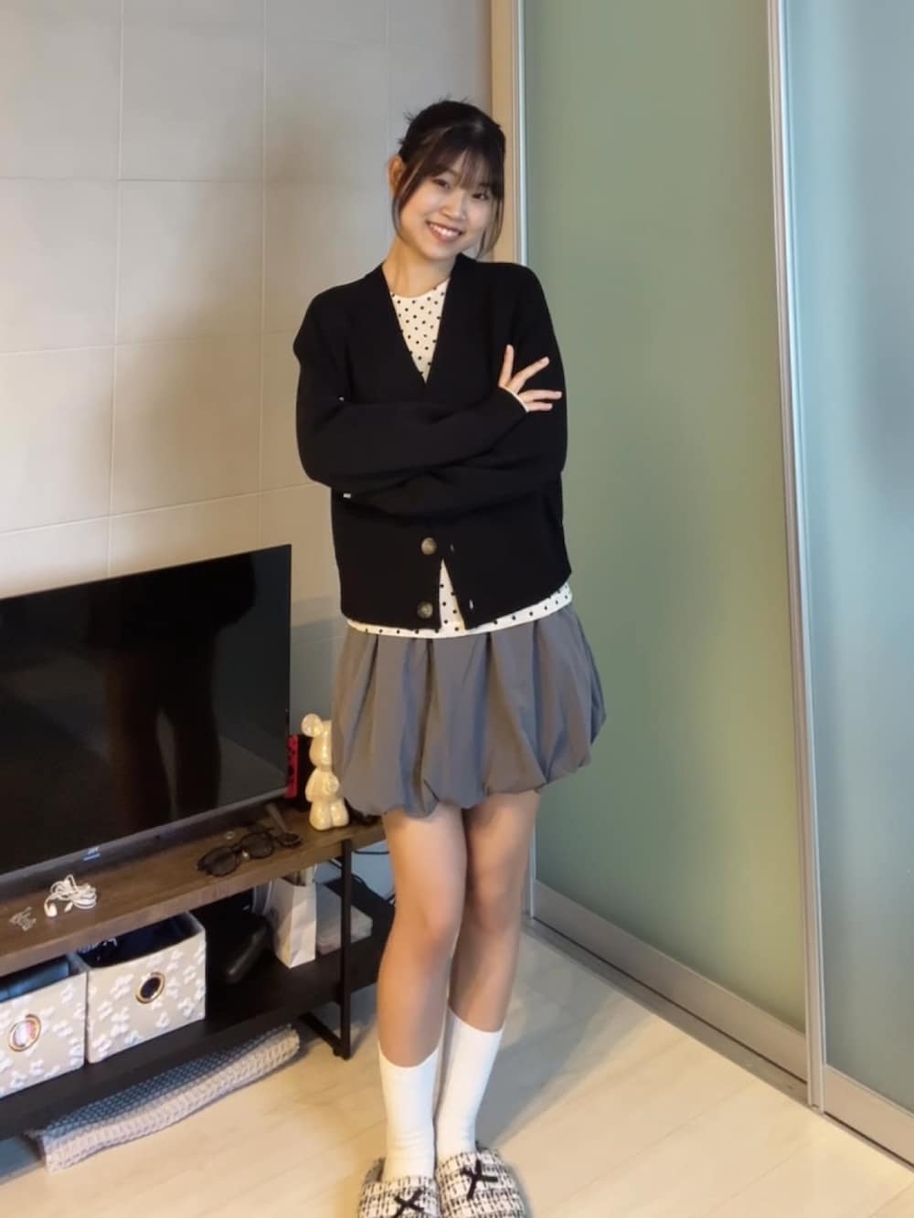 ブラック系のカーディガン/ボレロ、グレー系のスカート、ベージュ系のTシャツ/カットソーを着用したレディースの秋コーディネートの2枚目の写真