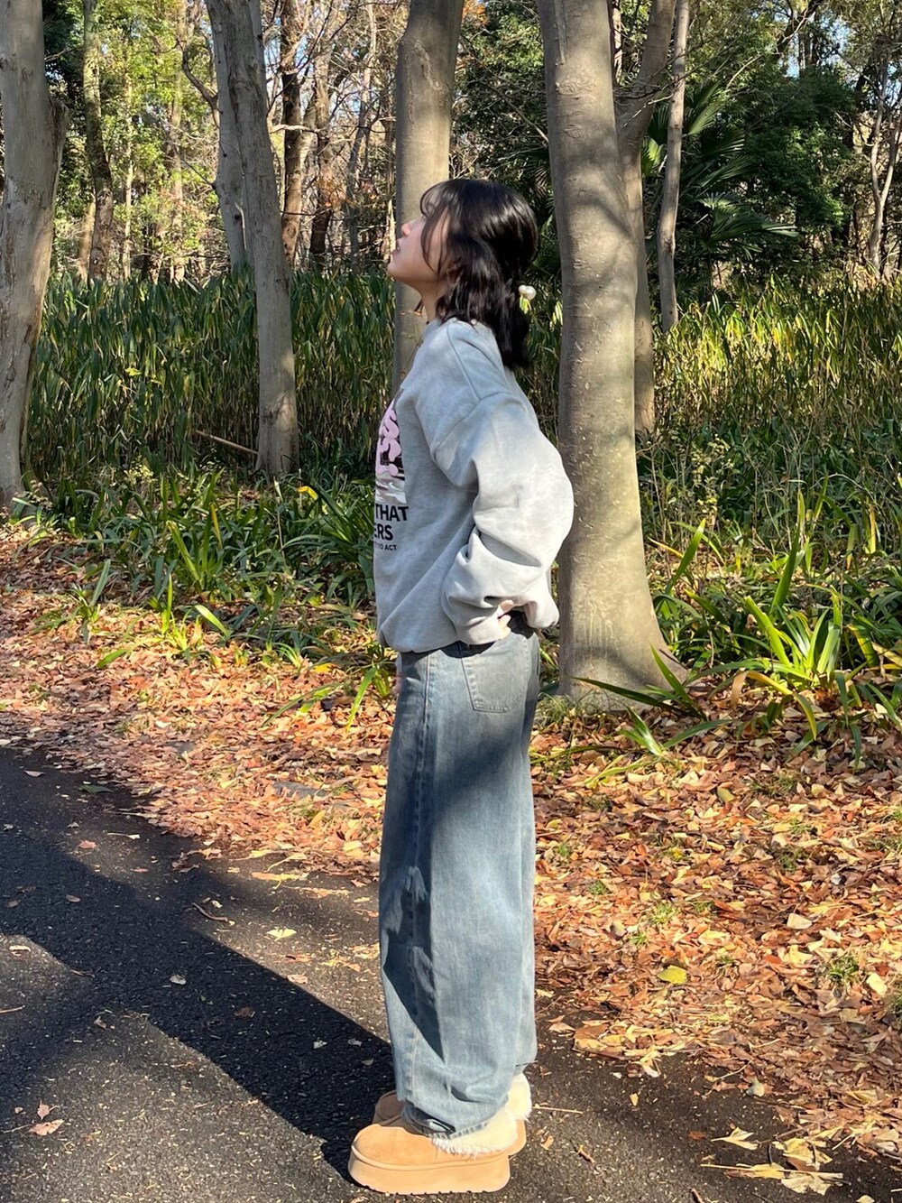 ブルー系のデニムパンツ、ベージュ系のブーツ、グレー系のスウェットを着用したレディースの冬コーディネートの2枚目の写真