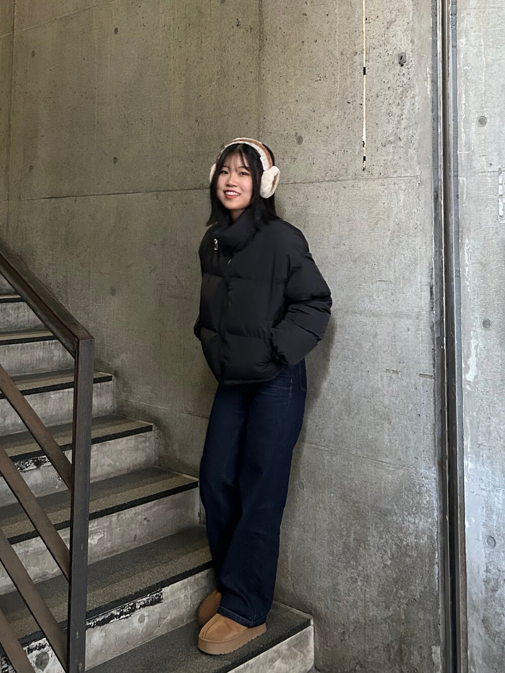 ブルー系のデニムパンツ、ベージュ系のブーツ、ブラック系のダウンジャケット/コートを着用したレディースの冬コーディネートの2枚目の写真