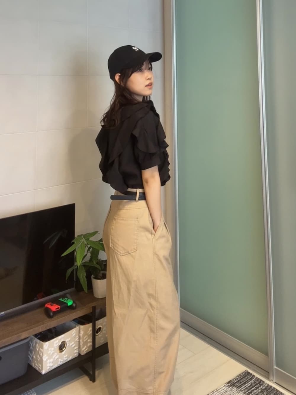 ブラック系のシャツ/ブラウス、ベージュ系のパンツ、ブラック系のキャップを着用したレディースの夏コーディネートの3枚目の写真